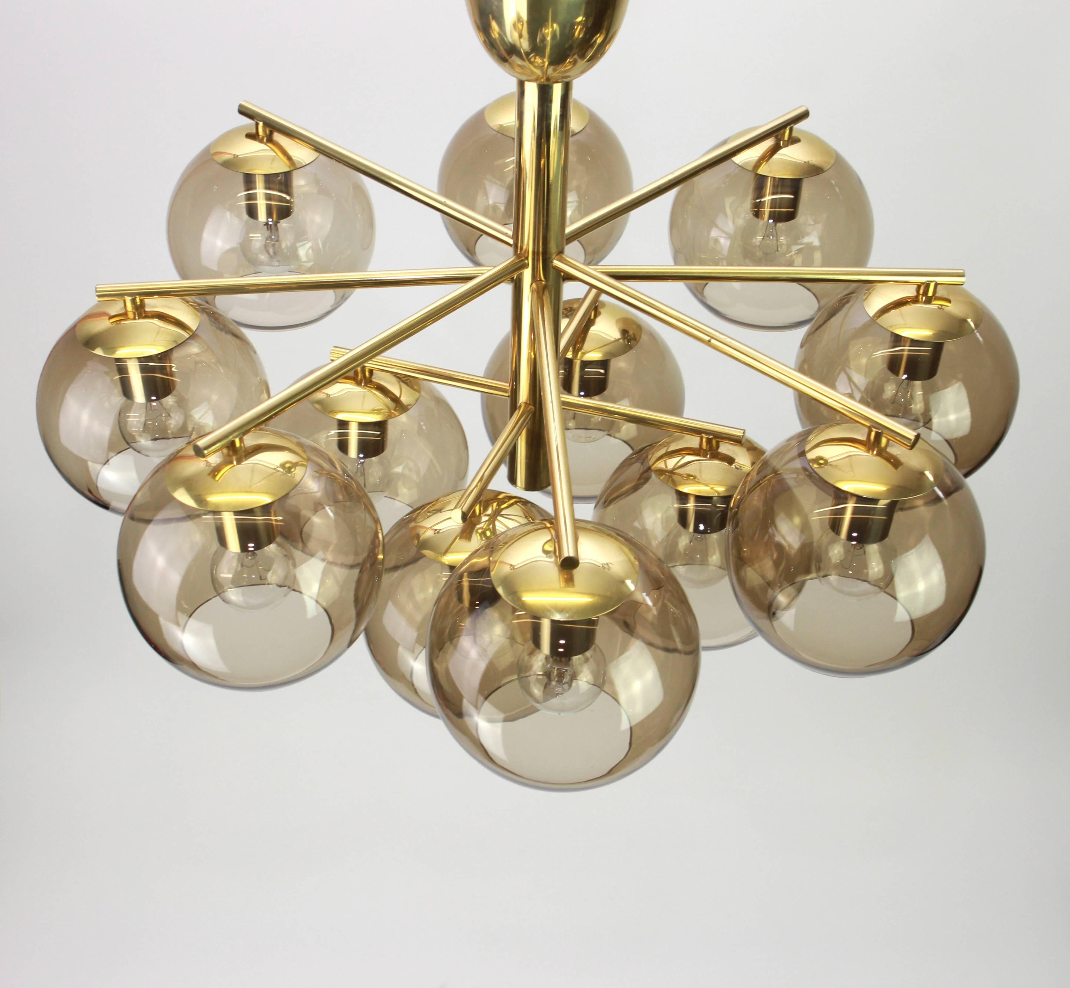 Twelve-light brass chandelier in the style of Hans-Agne Jakobsson.
Smoked glass in a very beautiful smokey brown color.
Made with brass and brass-plated metal, best of the 1960s.

High quality and in very good condition. Cleaned, well-wired and