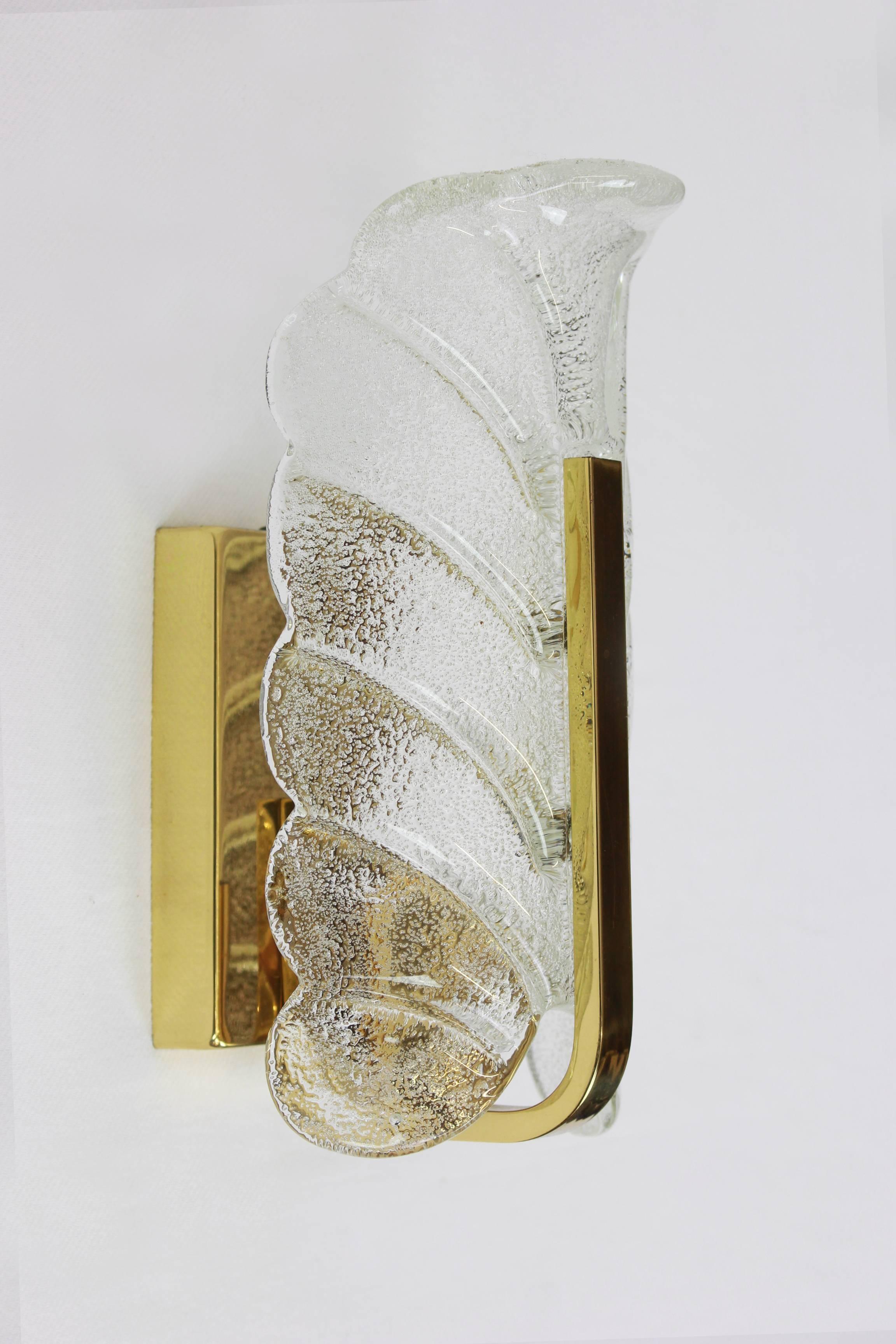 Very glamorous wall sconces designed by Carl Fagerlund for Orrefors glass, manufactured in Mid-Century, circa 1960-1969. Each sconce features a polished brass frame with one glass leave which has a matte frosted relief on the inside and is shiny on