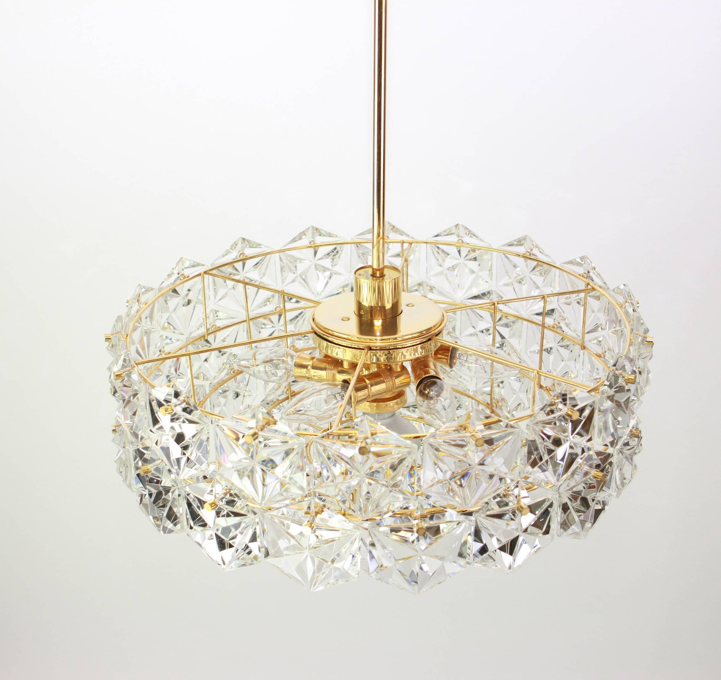 A stunning five-tier chandelier by Kinkeldey, Germany, manufactured in circa 1970-1979. A handmade and high quality piece. The chandelier features a 24 karat gold-plated five-tier structure with lots of facetted crystal glass elements.

High quality