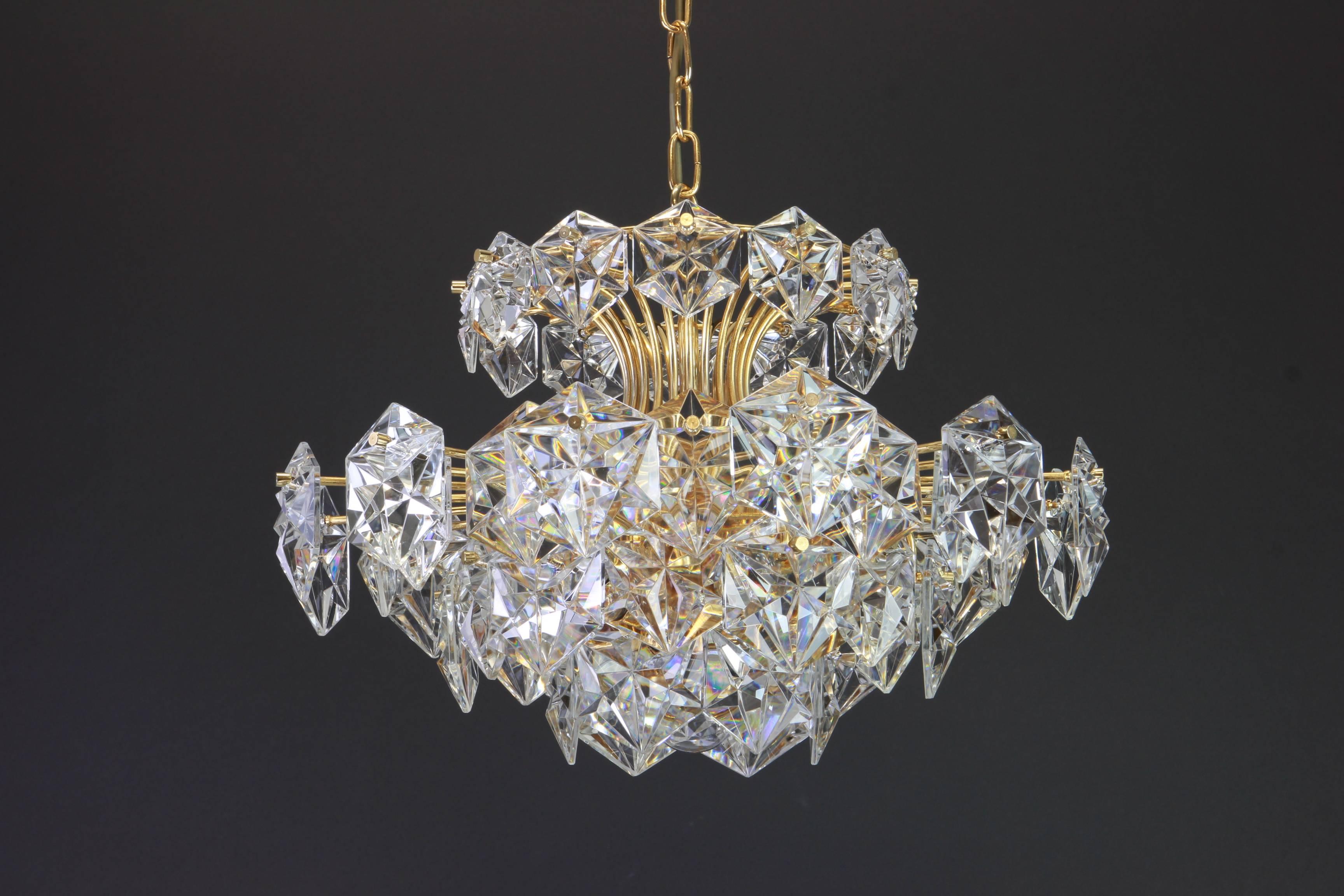 A stunning five-tier chandelier by Kinkeldey, Germany, manufactured in circa 1970-1979. A handmade and high quality piece. The chandelier features a 24 karat gold-plated five-tier structure with lots of facetted crystal glass elements.

High quality