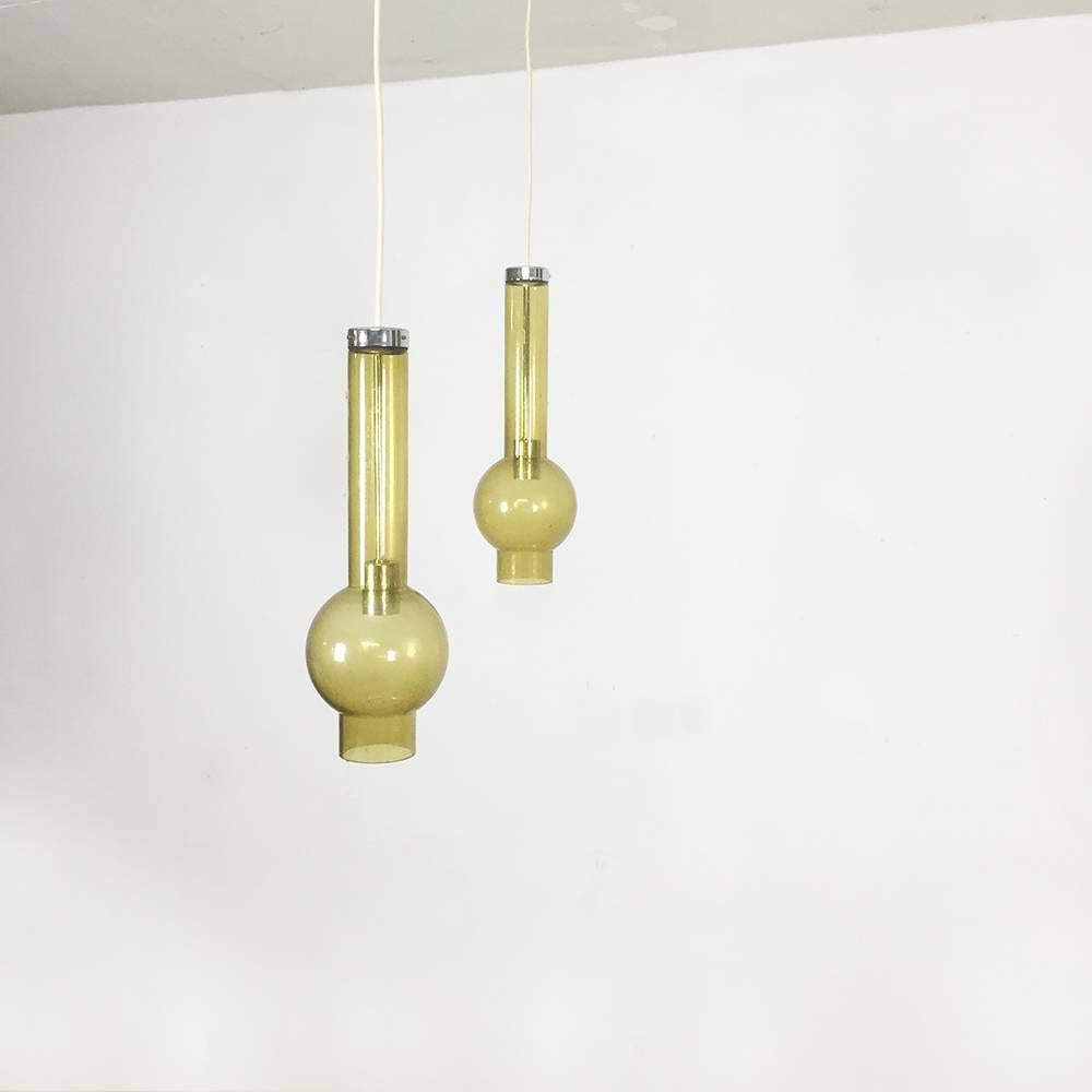 Set of three glass tubular lights.

Producer: Staff light, Lemgo Germany.

1960s.

This set of tubular pendant lights was designed produced in the 1960s by Staff Light, Lemgo, Germany. This lights are made of handblown green glass shades with
