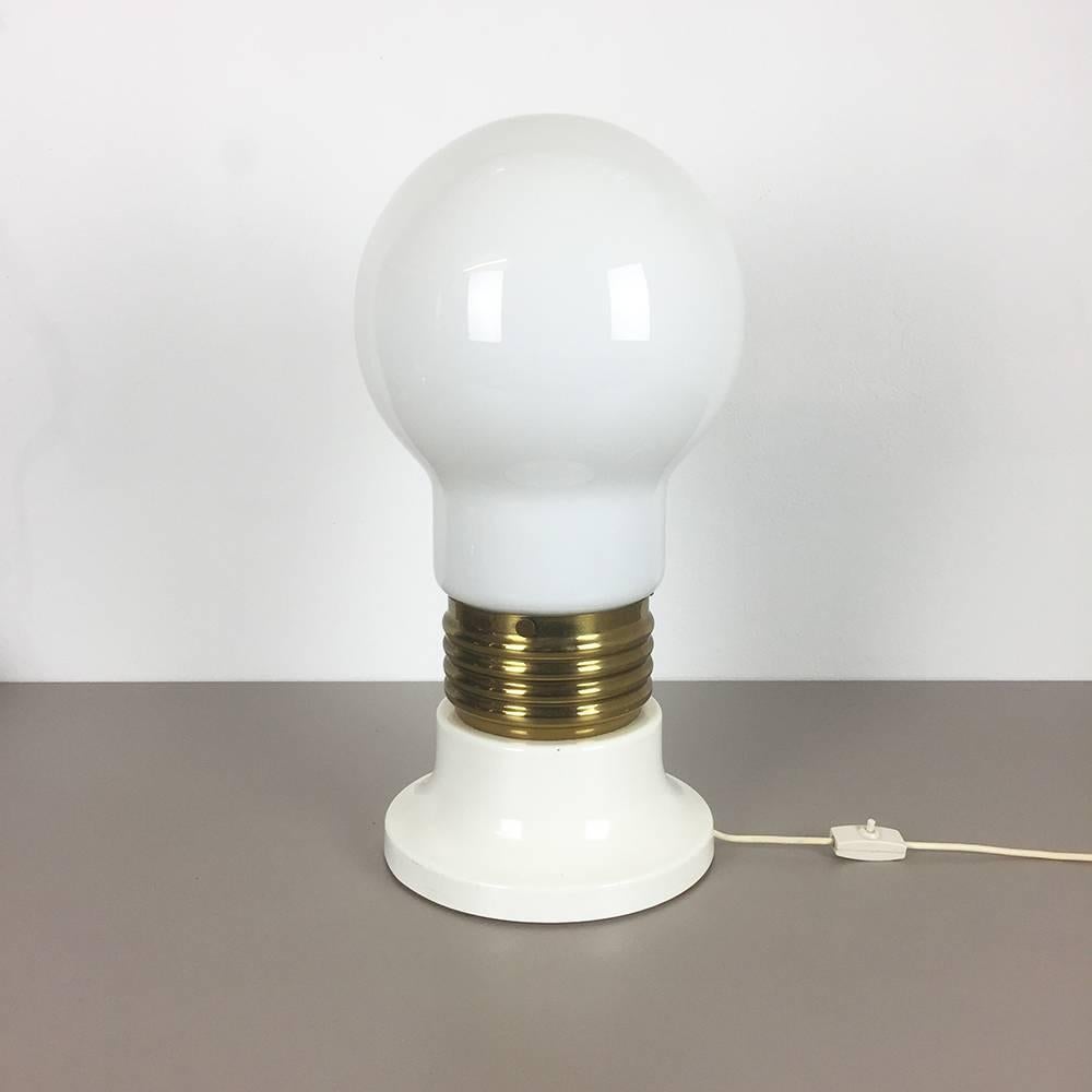 Giant bulb light,

origin Italy,

1970s.

Original 1970s Giant glass bulb table light. The base and middle of this light are made of solid metal, the base is laquered is white, the middle part has a brass tone finish. the huge glass shade is