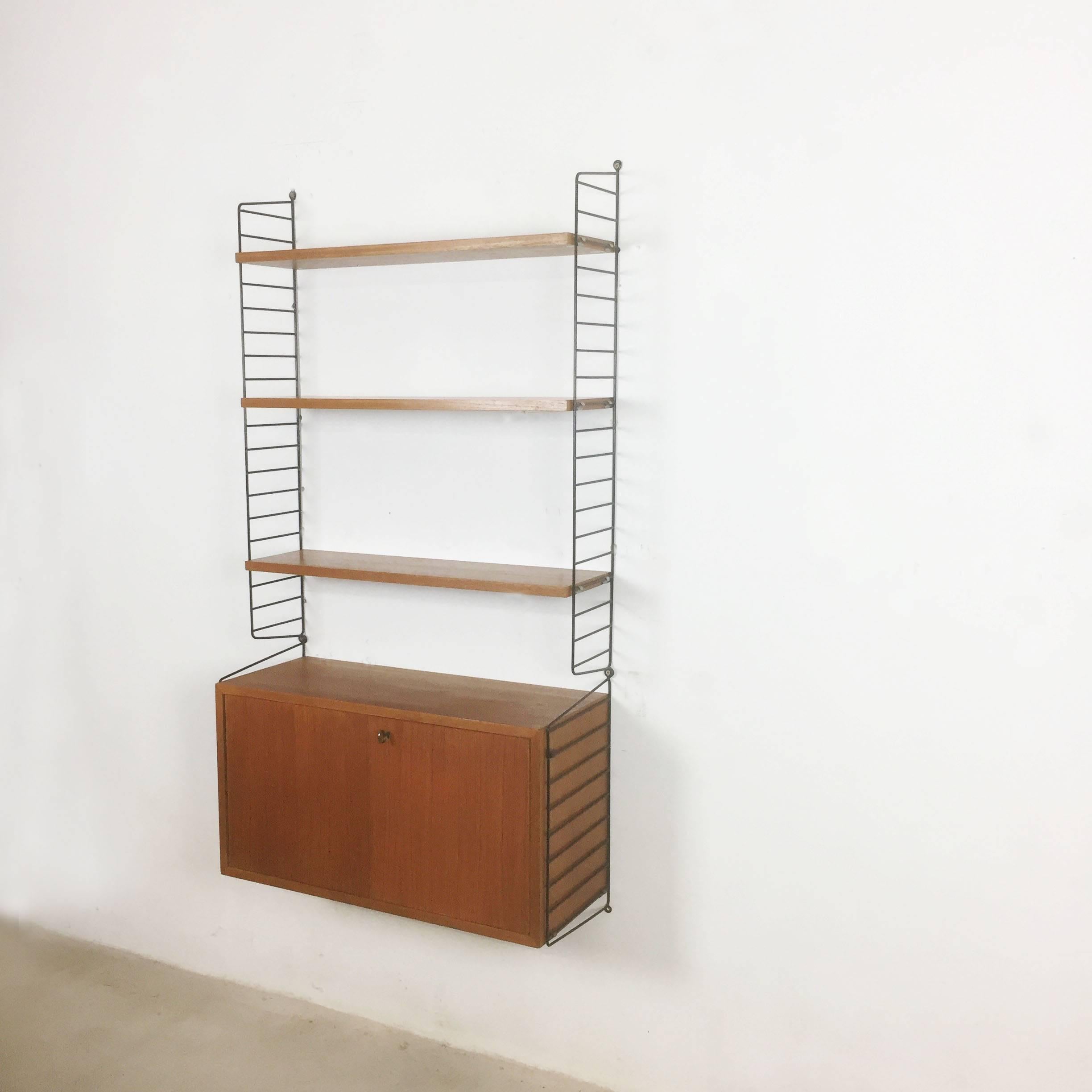 String Regal wall unit

Made in Sweden

Bokhyllan ’The Ladder Shelf’

Design: Nils und Kajsa Strinning, 1949

The architect Nisse Strinning was born in 1917. From 1940-1947 he studied architecture in Stockholm, before he designed the