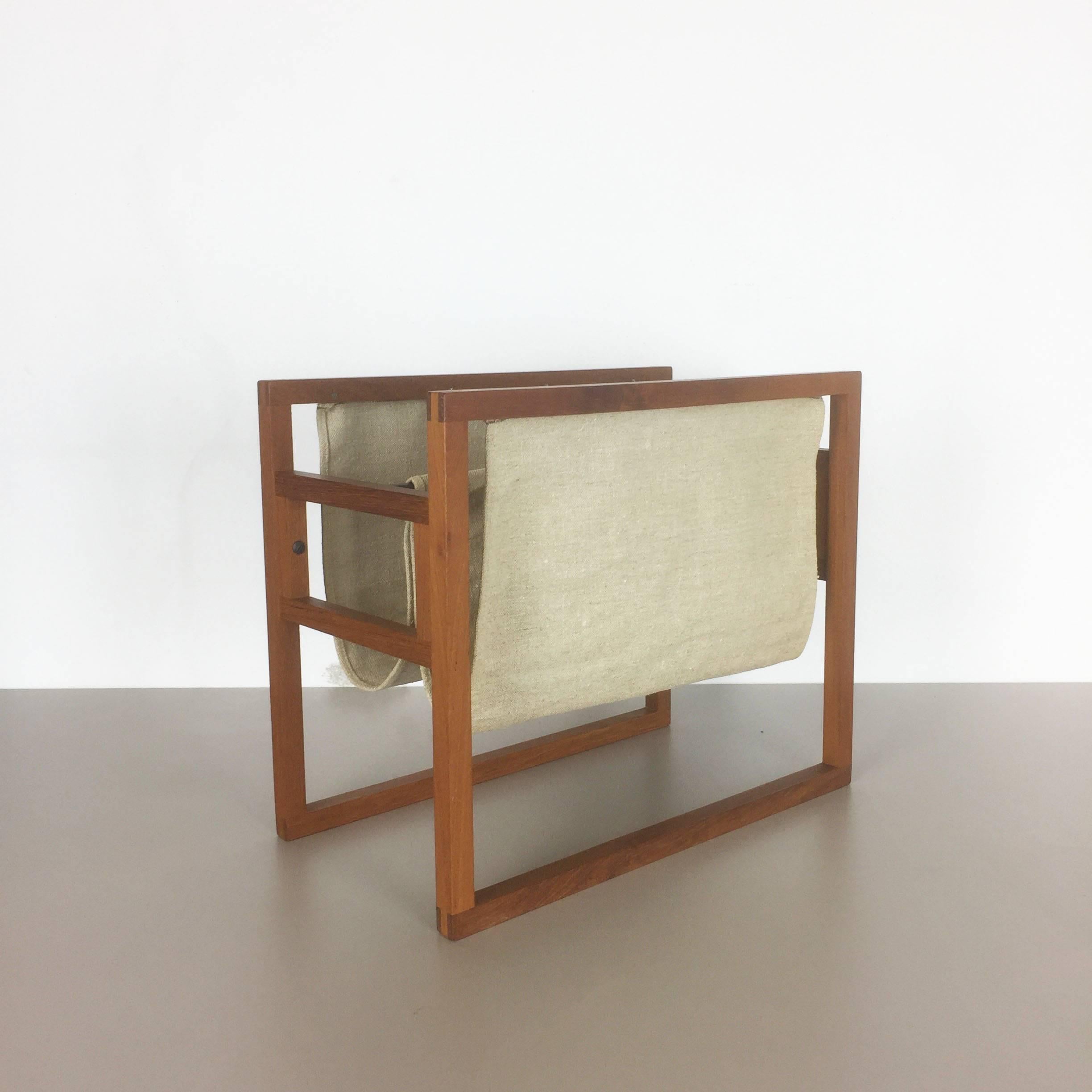 Teak magazine rack.

Designed by Kai Kristiansen.

Produced by Sika Mobler, Denmark,

1960s.

Original 1960s magazine rack was designed by Kai Kristiansen and produced by Sika Mobler, Denmark. The frame is made of solid teak wood with linen