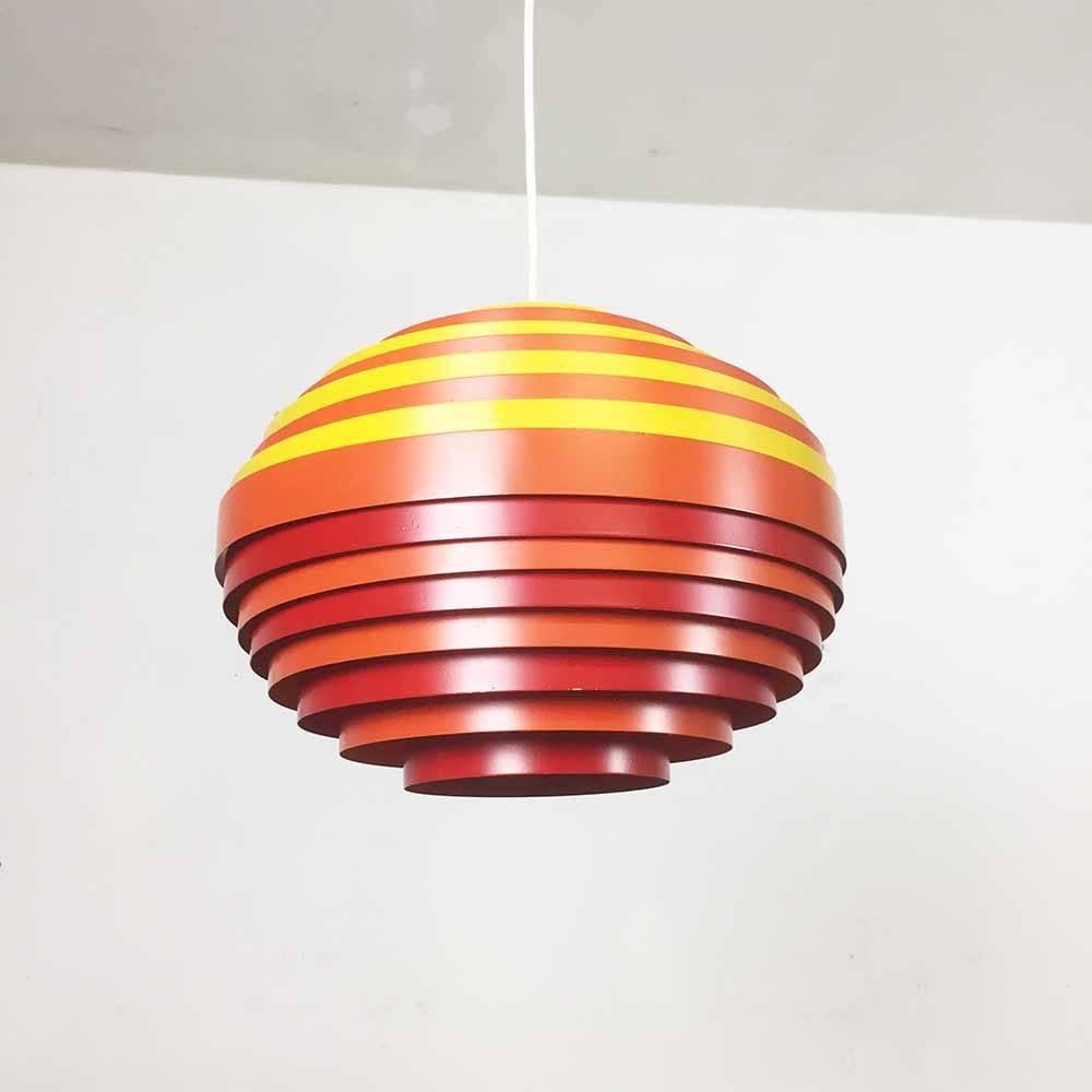 Multicolored pendant light.

Producer: VEST Austria.

1960s.

This 1960s hanging light was made by Vest Austria. The lampshade is made of solid metal, consisting of 15 lacquered metal rings in shades of red, orange, and yellow. The socket and