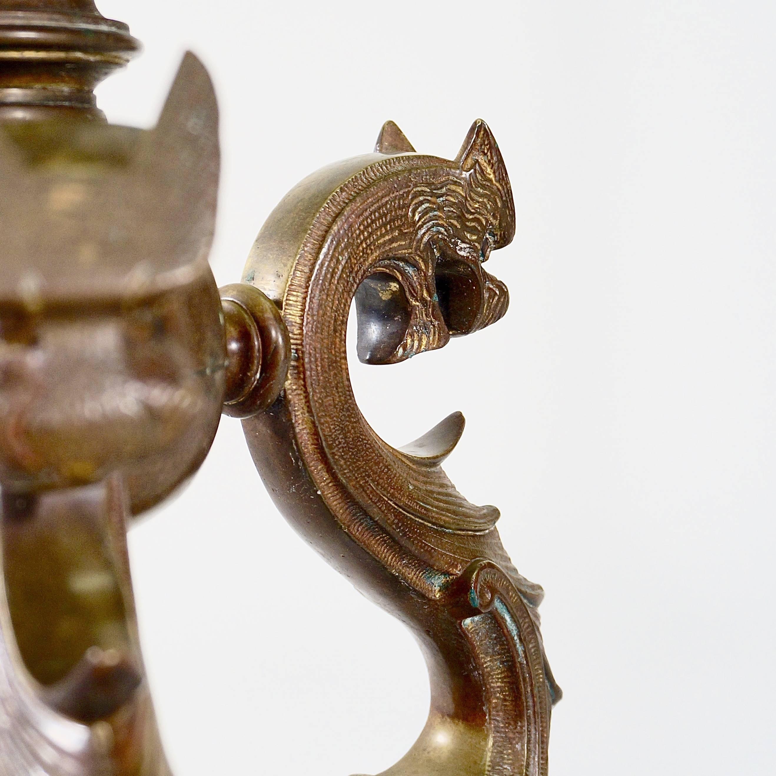 The tripod base with lion paw feet and dragon bodies with traces of original gilding joined by a central boss supporting a fluted column with an extending gilt brass stem.

Possibly by Ferdinand Barbidienne (1810-1892).

Originally a torchere