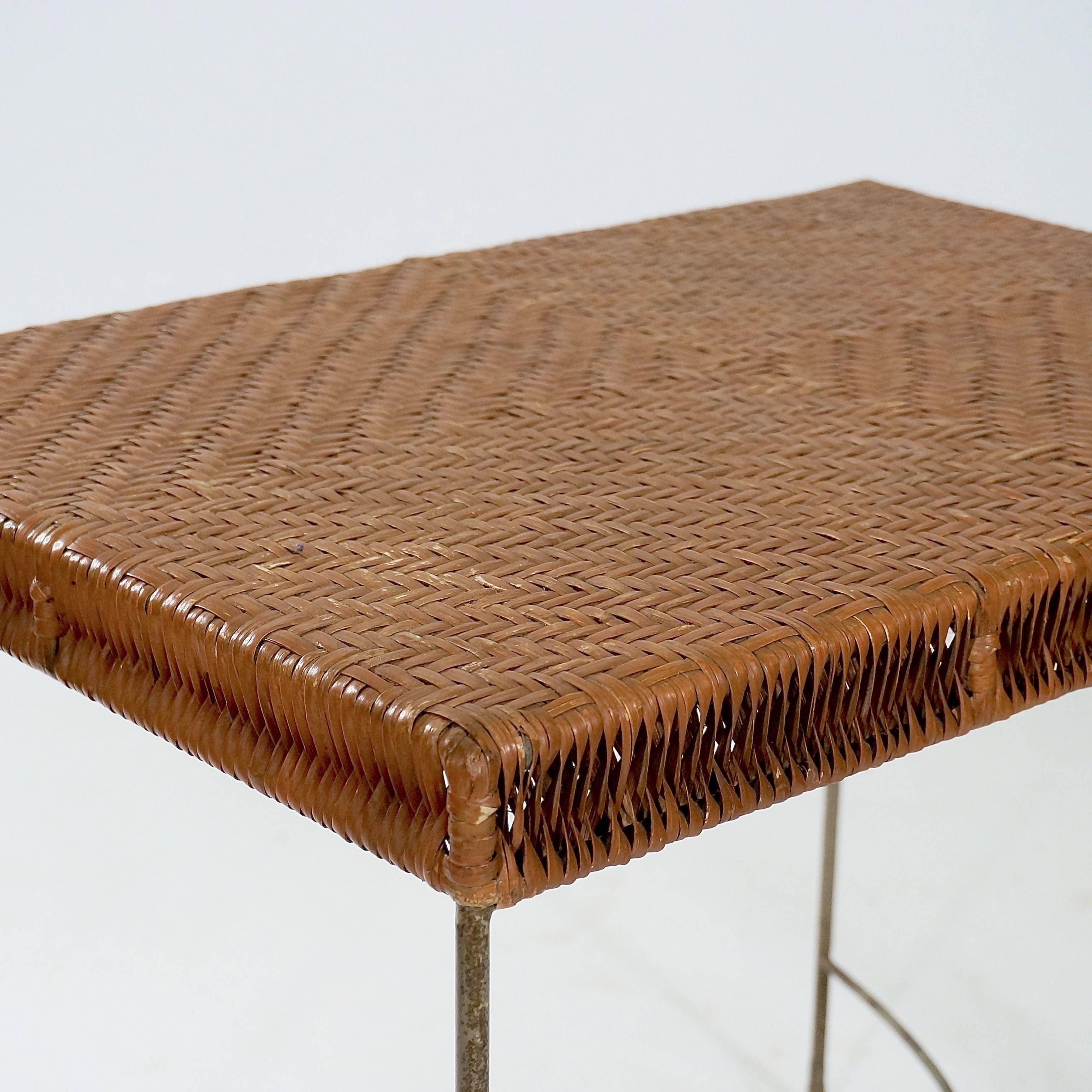 The simple metal under-structure with rib turned feet and interlaced stretcher supporting a rattan top.

France, circa 1950s.