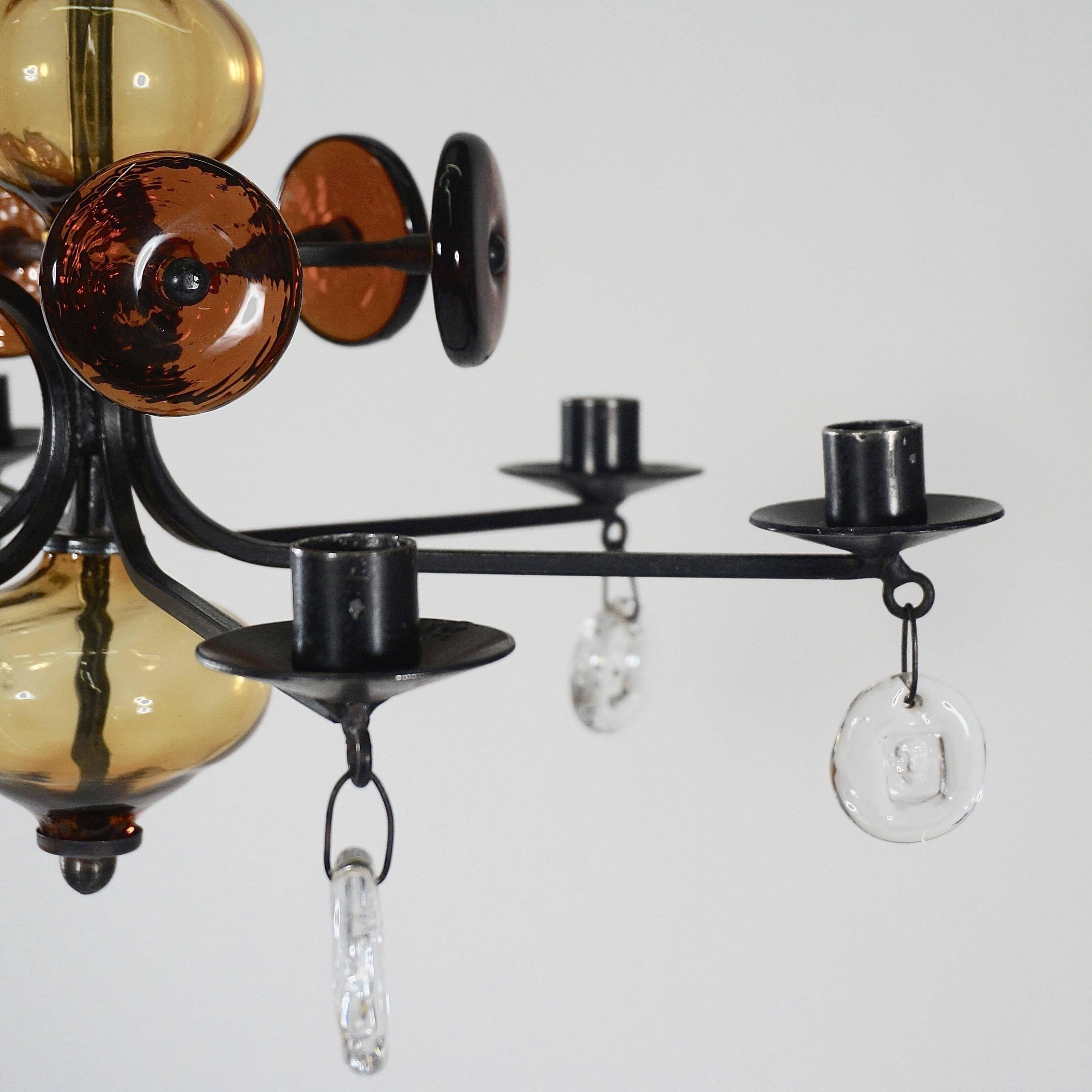 A wrought iron and glass chandelier with four main cross-arms and two small subsidiaries. Hung with handmade clear and tinted glass prisms.

Height excluding the adjustable height hanging rods: 137 cm.
 
Höglund was a maverick painter, sculptor