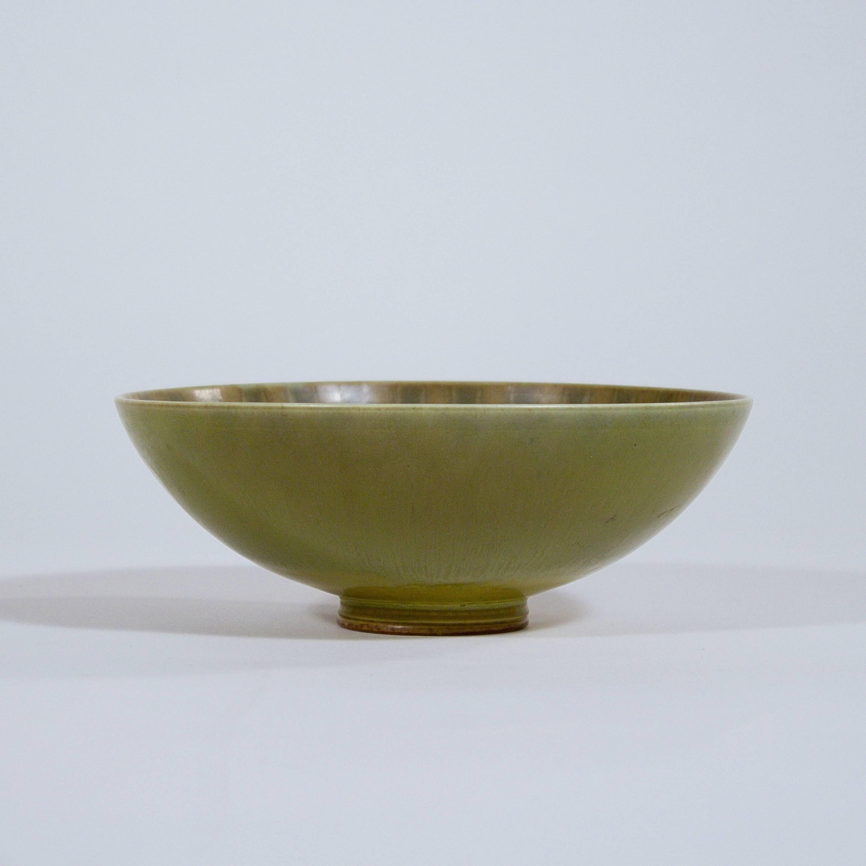 A circular stoneware footed bowl with a fine hare's fur green glaze by Berndt Friberg (1899-1981).

Signed to the base.

Designed for Gustavsberg, Sweden, circa 1950s.