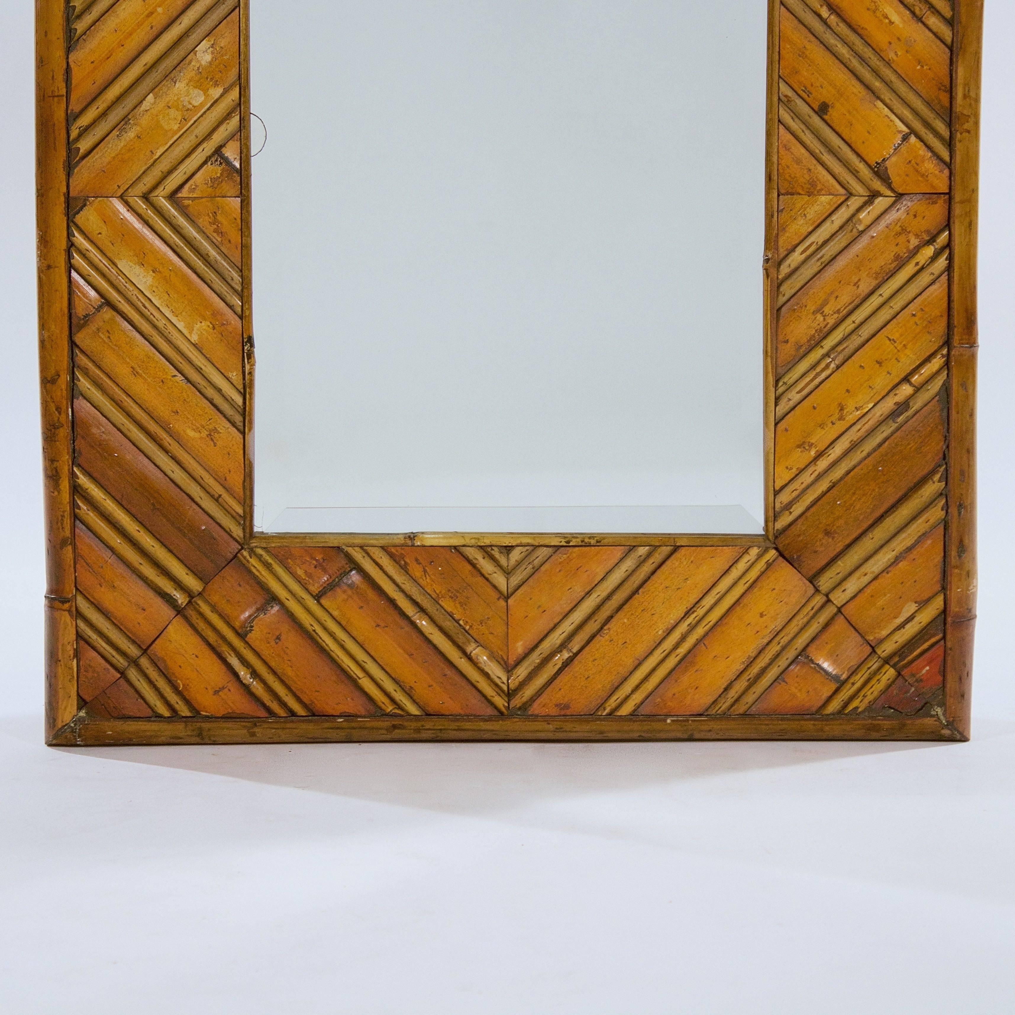 The cane and bamboo frame enclosing a bevelled plate.

France, circa 1950s.