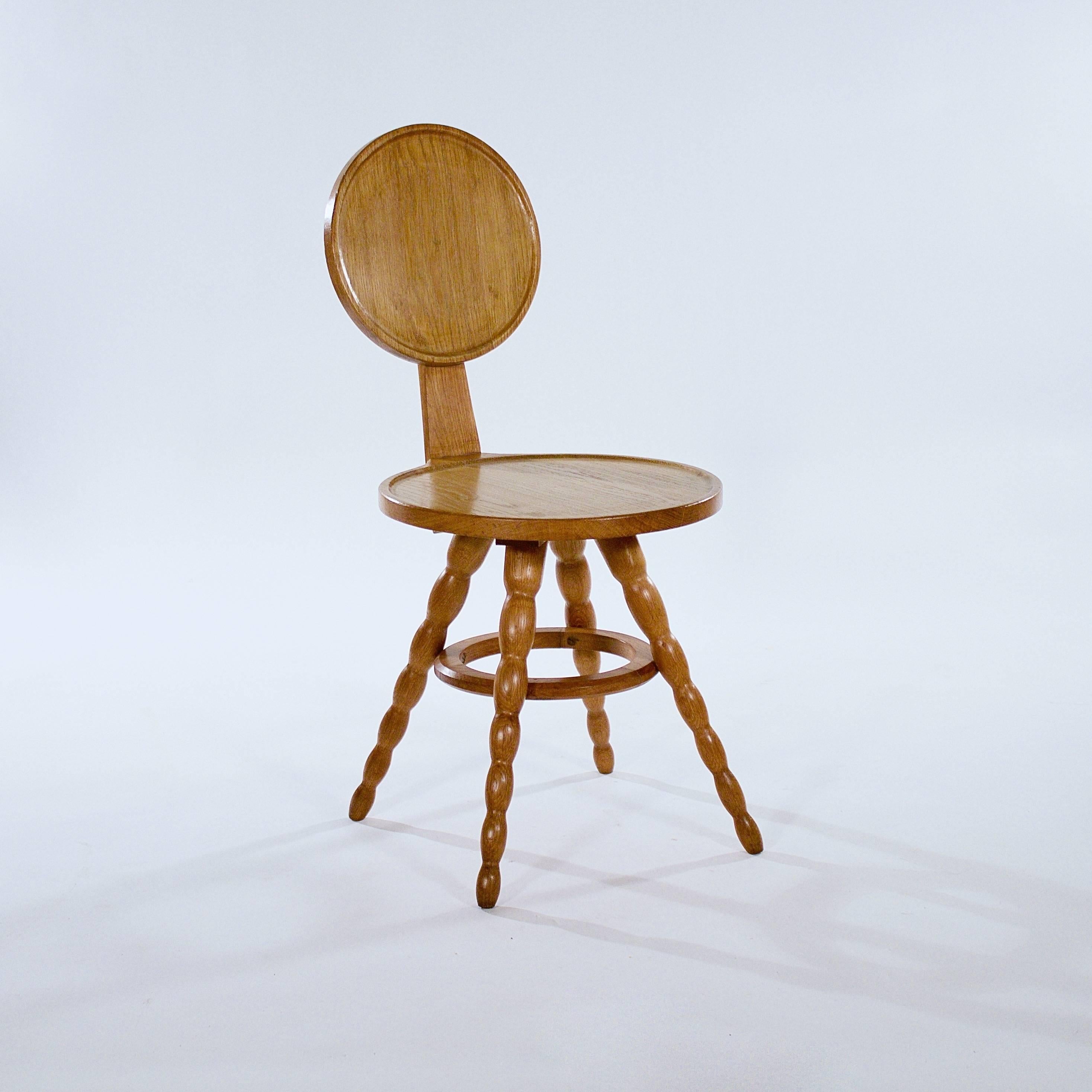 The circular back with a handle support above a circular seat on four splayed bobbin turned legs joined by a circular stretcher,

France, circa 1950s.