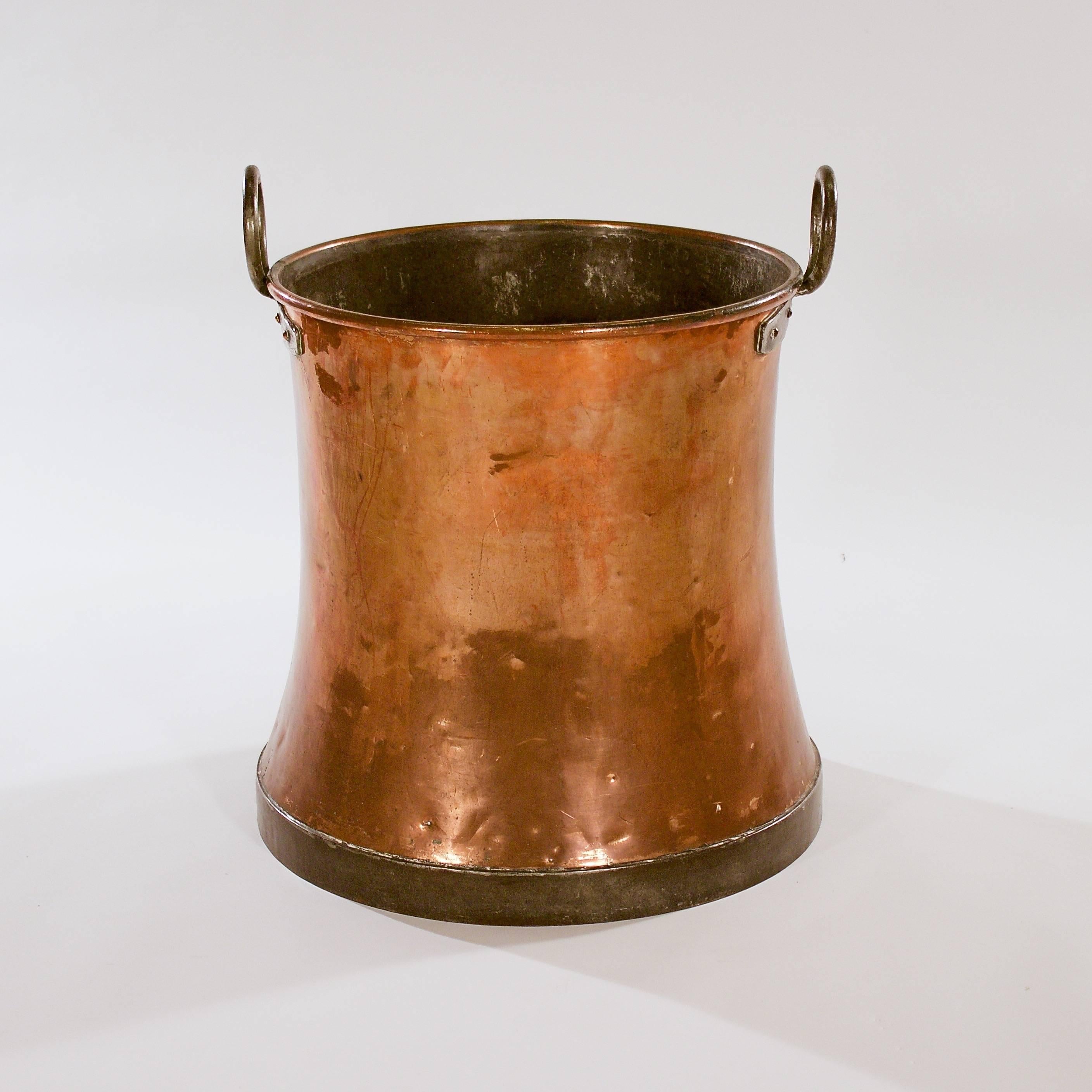 The waisted copper cylindrical body with two iron loop handles on a footed base, 

Sweden, circa 1880s.