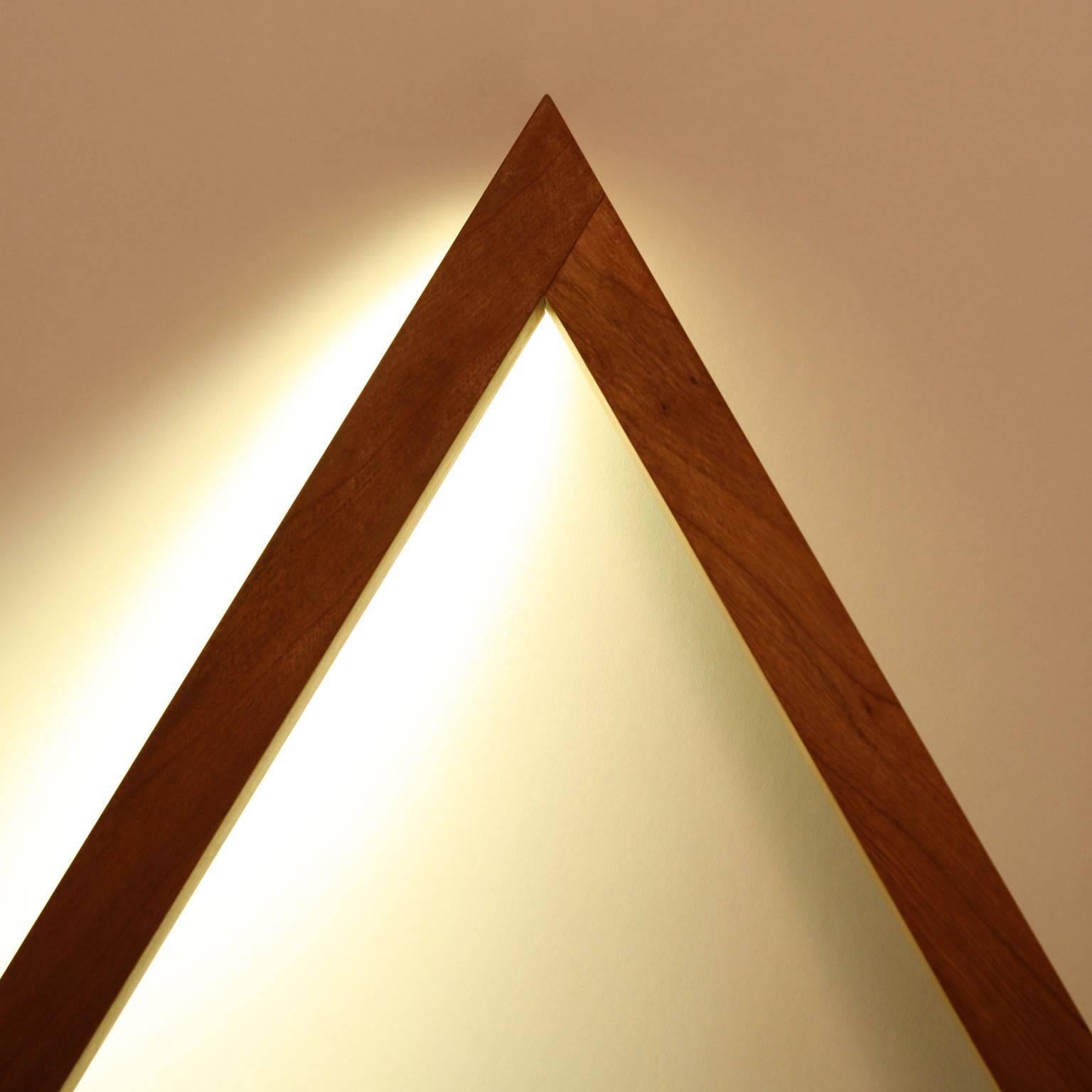 Fort Makers' Triangle 2 Cherry Line Light is made in Brooklyn by Noah Spencer. This sculptural LED light juxtaposes hard lines with soft reflected light and emits an ambient aura. The lifespan of an LED strip is approximately 50,000