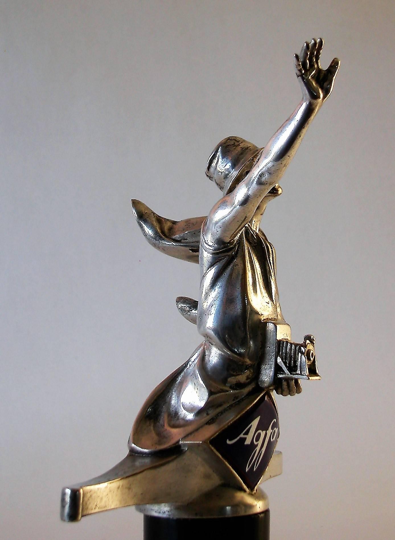 One of the most rare car mascots (hood ornament) in the world, made for AGFA in the roaring 1920s.
 
This AGFA lady is silvered (nor chromed nor nickeled) and the design is based upon an AGFA film poster from Marcello Dudovich from 1922.
AGFA had