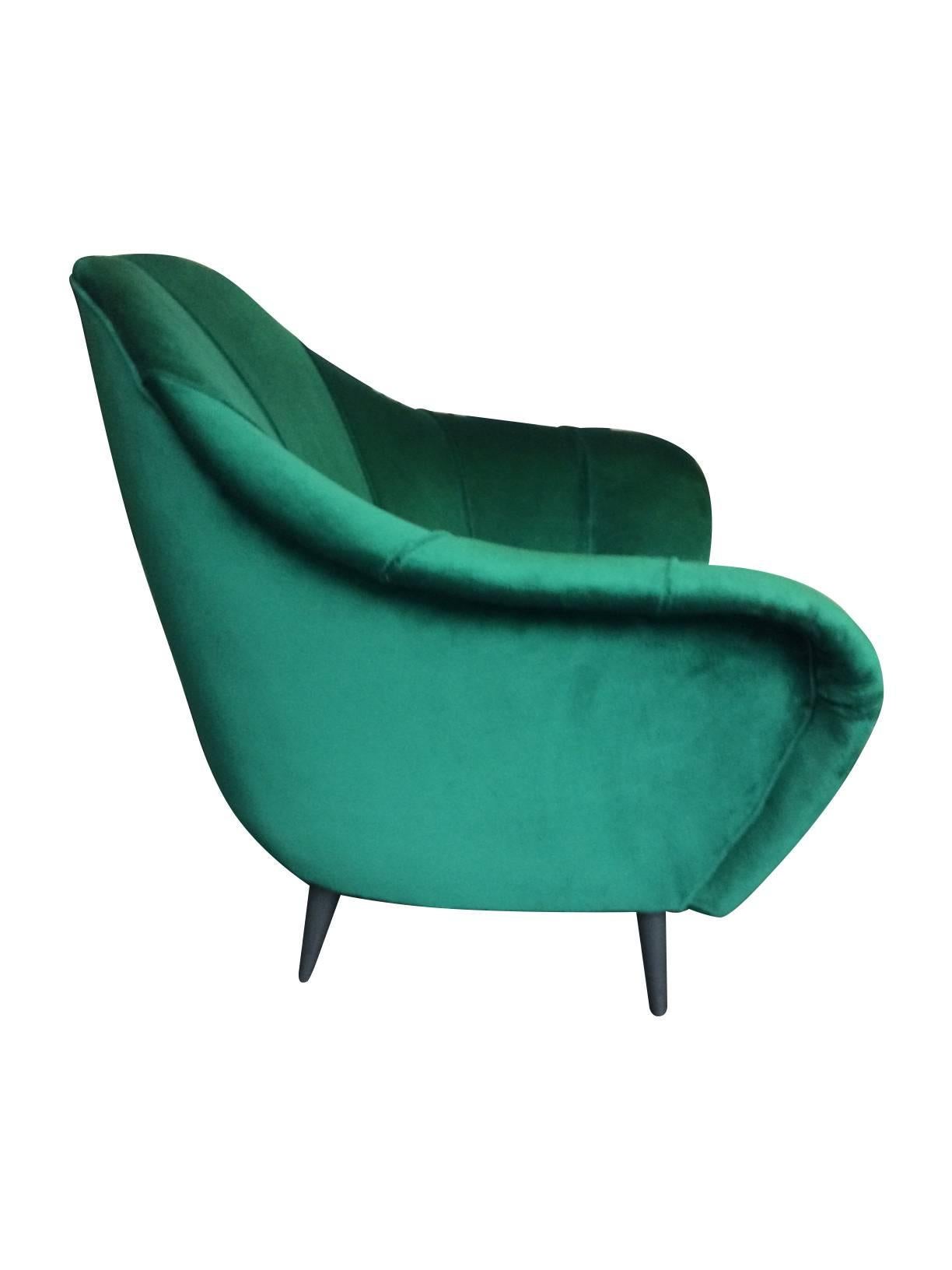 A beautiful Italian armchair in the style of Gio Ponti newly re-upholstered in emerald green velvet, with pleated back and ebonized wooden legs. Also see matching sofa available too.