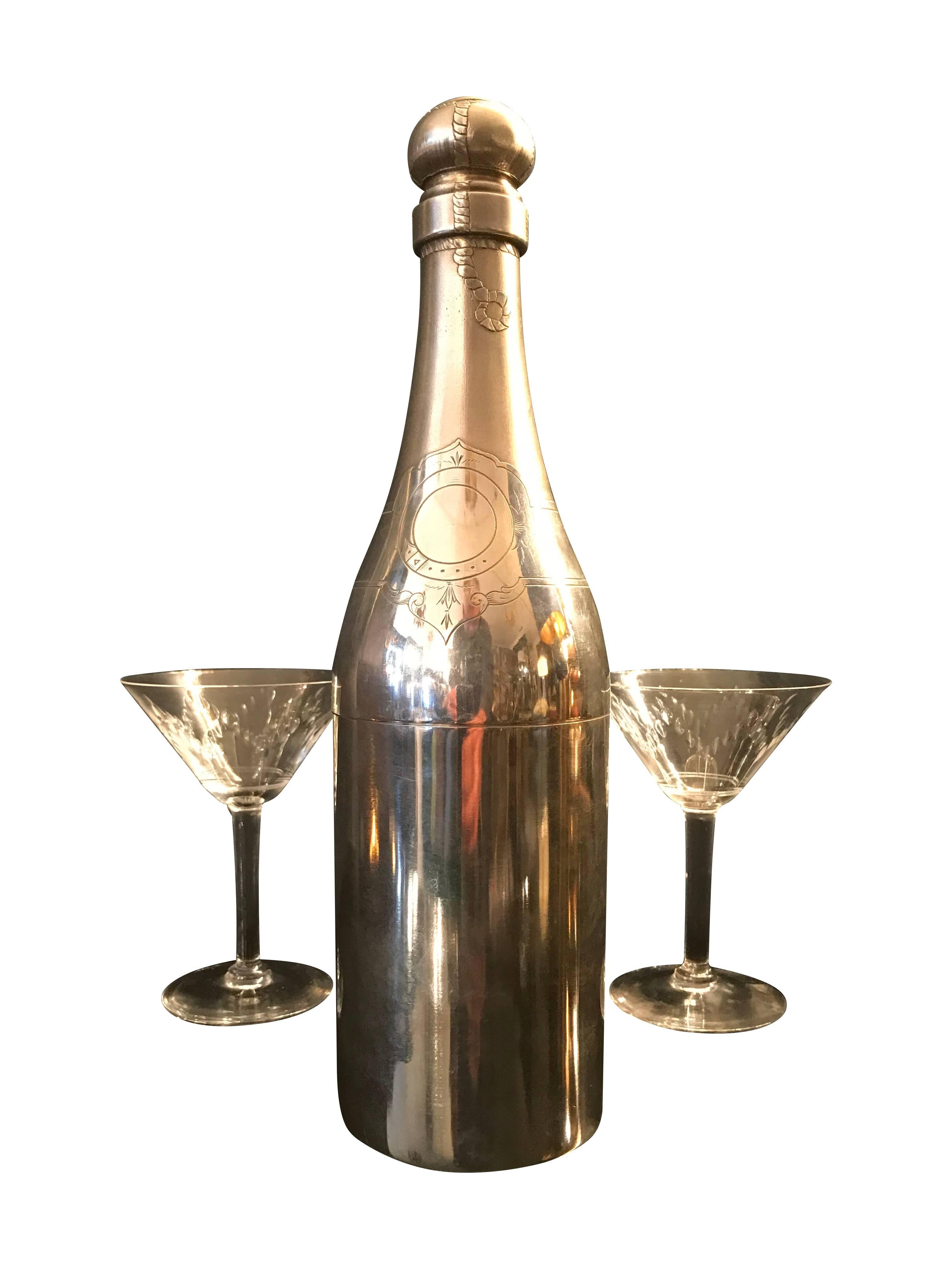 A rare silver plated Champagne bottle cocktail shaker with engraved label, foil and cork wire detail. The Shaker separates in just below the shoulder to fill with ice and cocktail mix and the cork comes off to pour the cocktail through the top