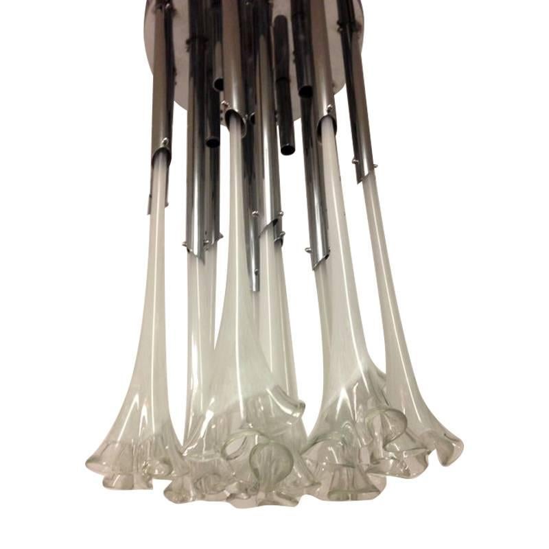 A large chrome and Murano glass flower chandelier with 13 fluted glass flower shaped drops, in two different sizes. The glass drops are all handblown with clear and white glass, suspended from chrome tubes, surrounding four bulbs. 

