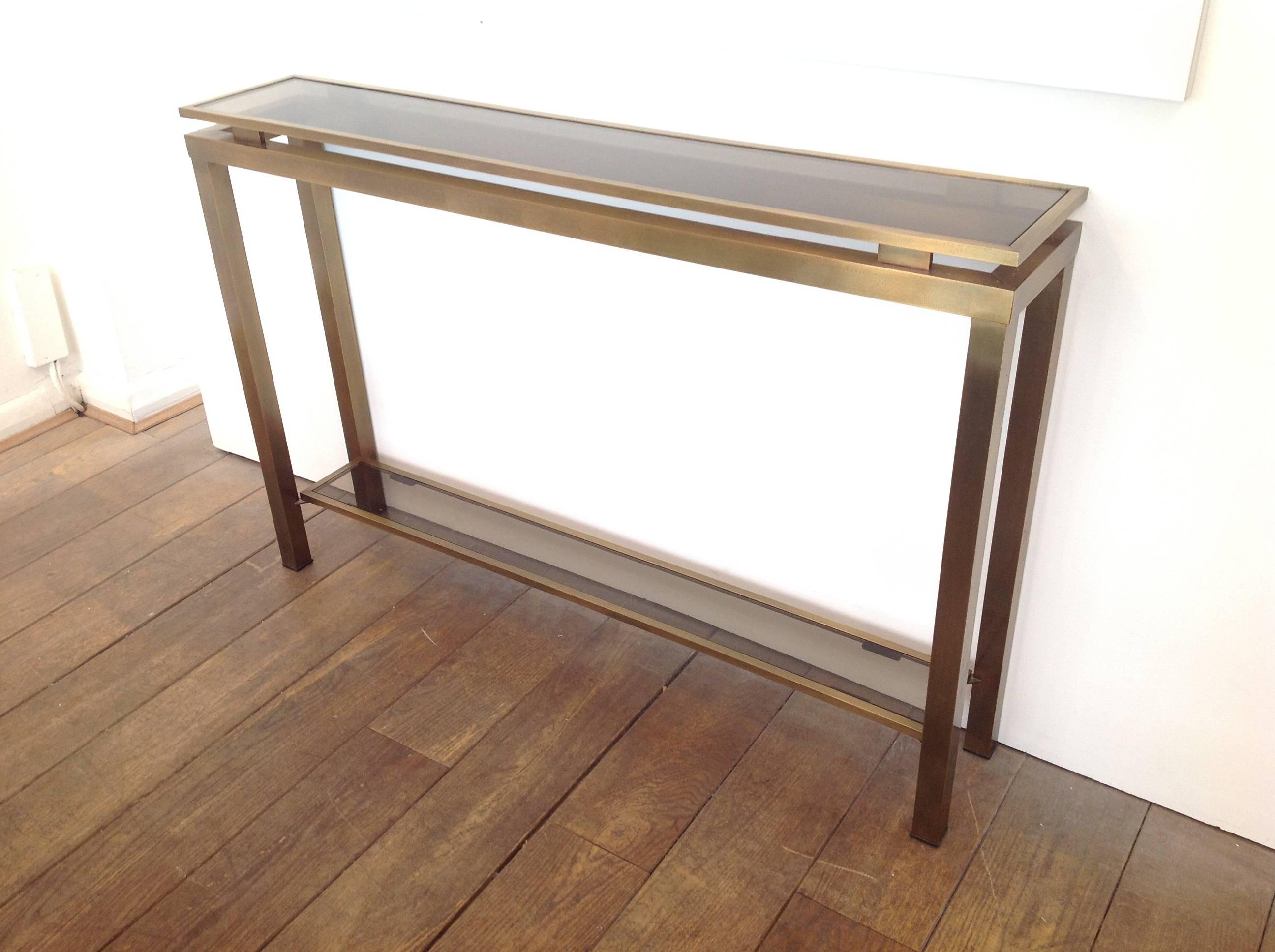 A Guy Lefevre console table with gilt metal double edged frame and two smoked glass shelves. Also available is matching Guy Lefevre mirror and coffee table.