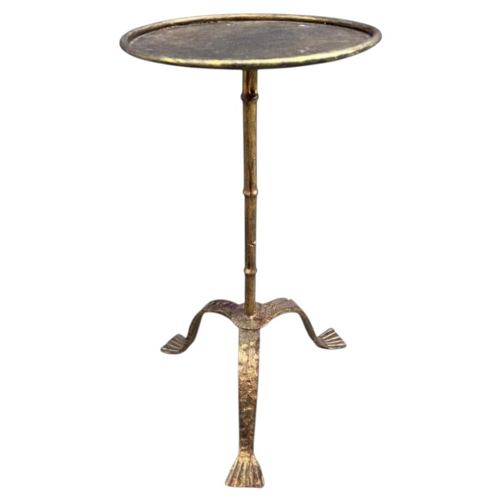 A Spanish 1950s gilt wrought iron martini table with three shaped legs