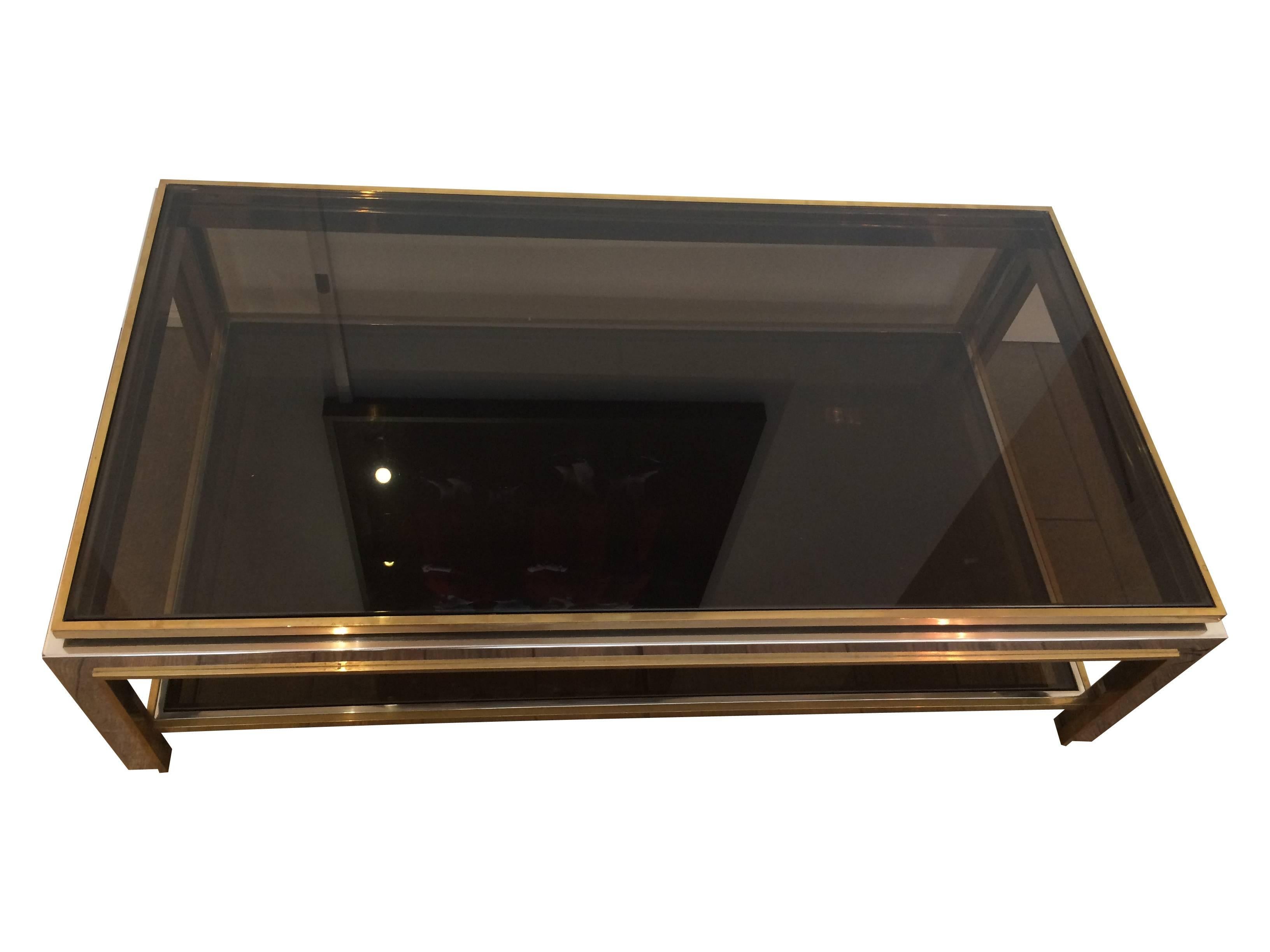 A stunning 1970s Jean Charles chrome and brass coffee table with two shelves of thick smoked glass. There is a slight chip on the underside of the top plate and the piece is priced accordingly. This would be easy to replace.