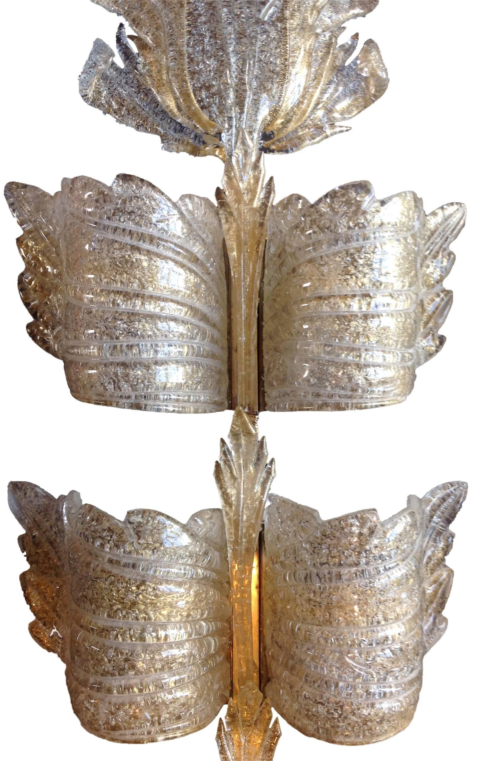 A large gold leaf "Champagne" Murano glass wall sconces by Seguso, Murano, Italy. The sconce has six curved glass leaves that surround six bulbs beneath, mounted on a brass wall bracket. Three slim central glass leaves run up the middle