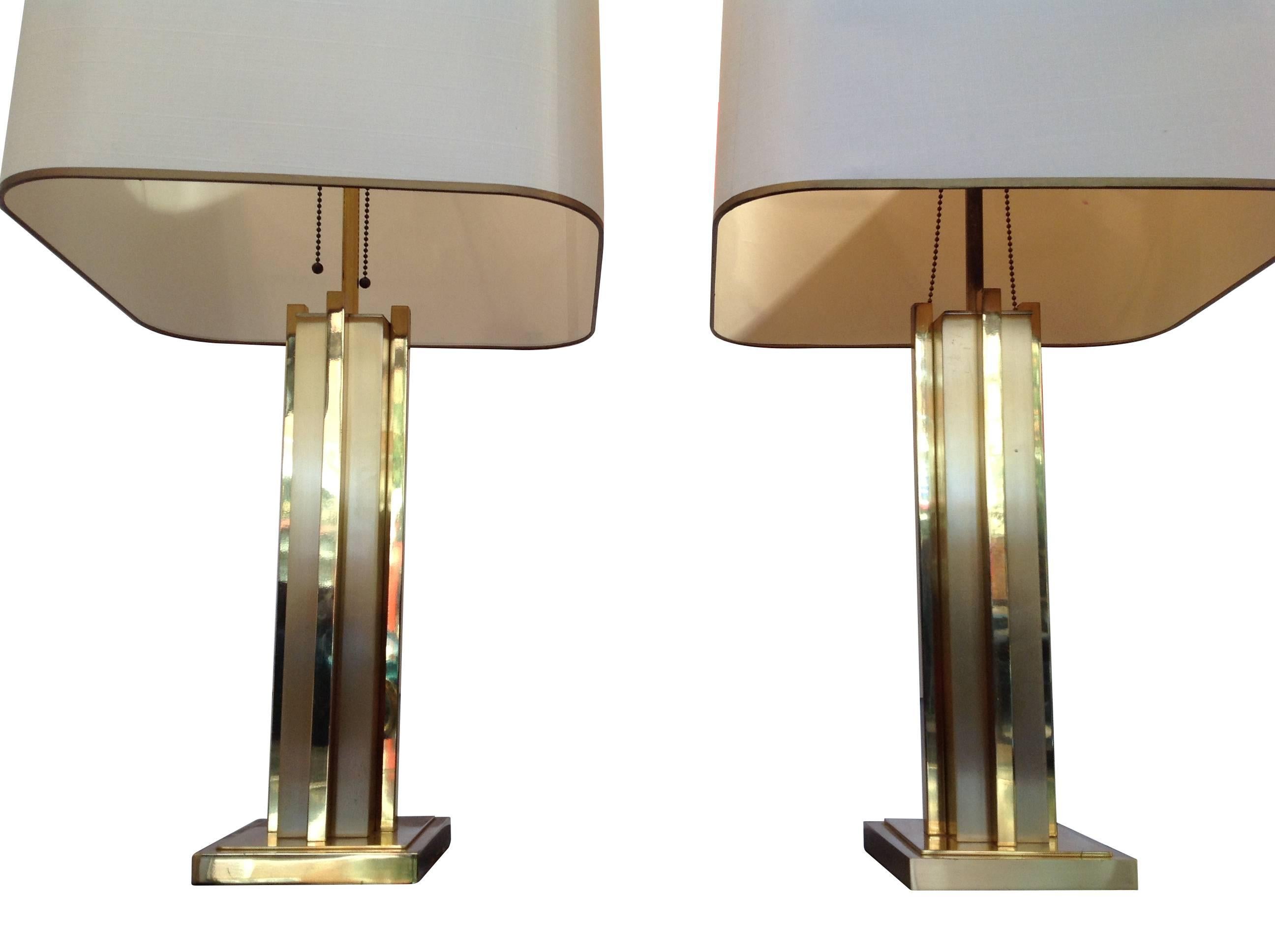 A large pair of Willy Rizzo lamps with polished and brushed brass finish on stem and base, with original cream shades with gold detailing on the rim. New bespoke black and gold shades can be made to order if required. Both re-wired with antique gold