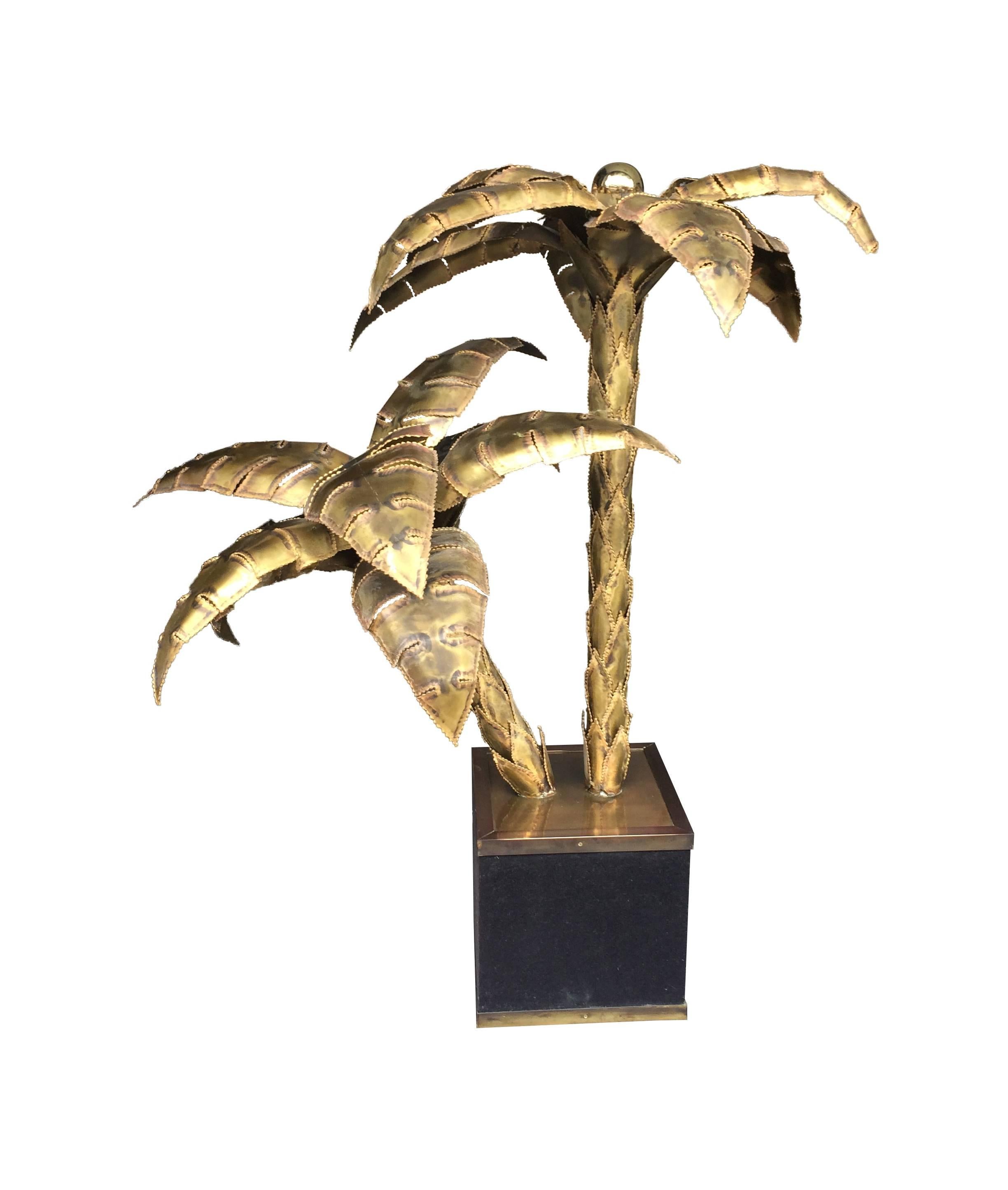 A Maison Jansen original palm tree table lamp, with two brass palm tree stems with a light in the top of each. Mounted in a felt covered base with bronze edging, re wired with antique cord flex and dimmer and pat tested.
  