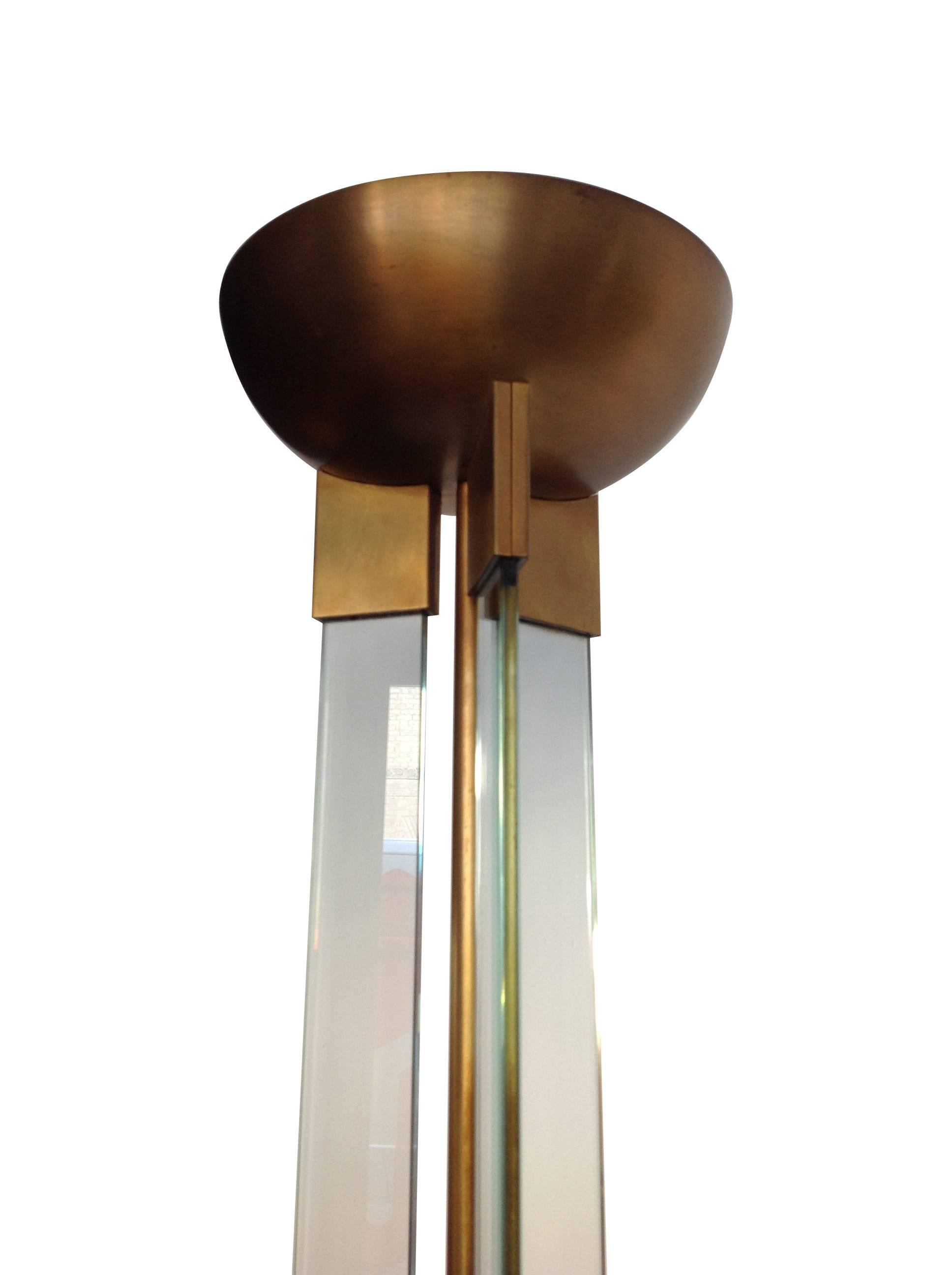An Art Deco style brass and glass floor lamp, with circular brass base, supporting a brass central stem surrounded by three glass columns. In the top bowl is a halogen uplighter, re-wired with antique cord black flex, floor switch or dimmer and PAT