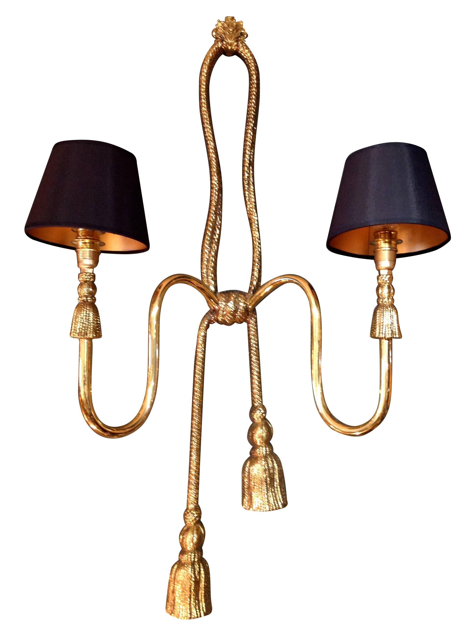 A pair of large Valenti brass rope and tassel wall lights, each with two-lights and new bespoke black shades with gold linings. Stamped on the reverse 