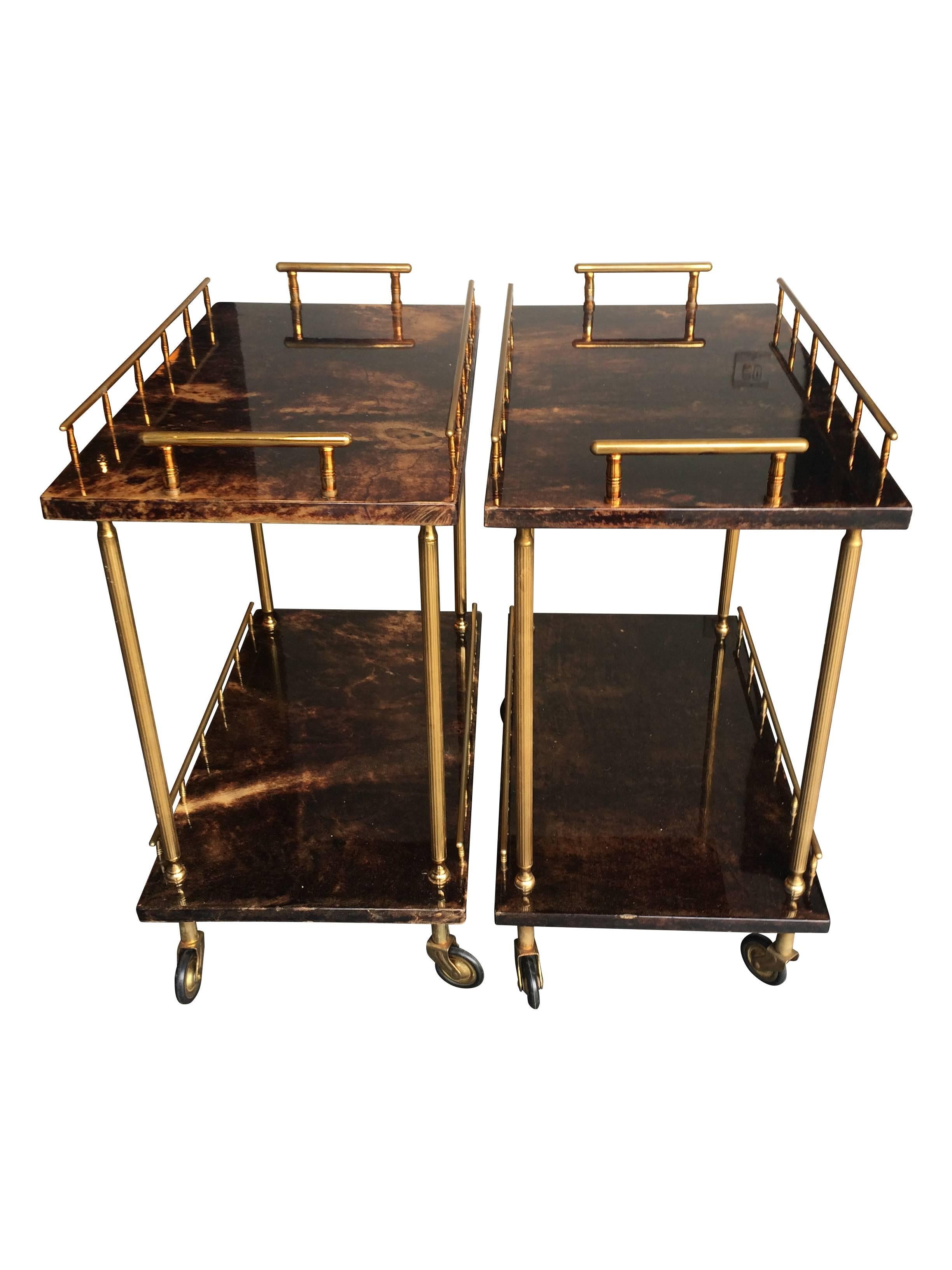 A lovely pair of small Aldo Tura two-tiered bar trollies in gloss lacquered, brown goatskin with brass frame and castors. In good original condition with no fading or staining. A great size and would be ideal to use as side tables or bar trollies.
