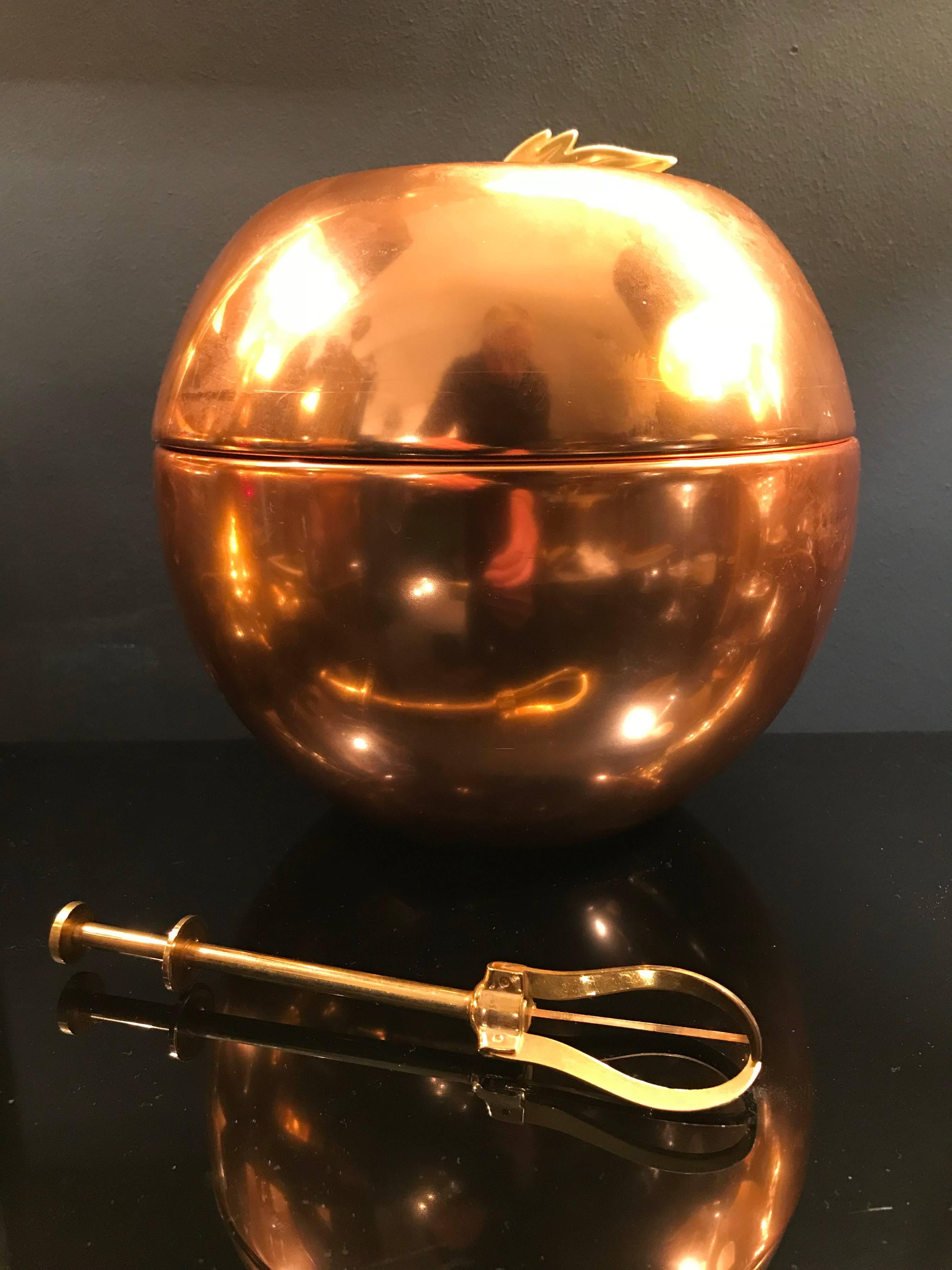An apple shaped copper spun ice bucket with brass leaf detail handle on the top with aluminium lining by Thermalite, England.
 
