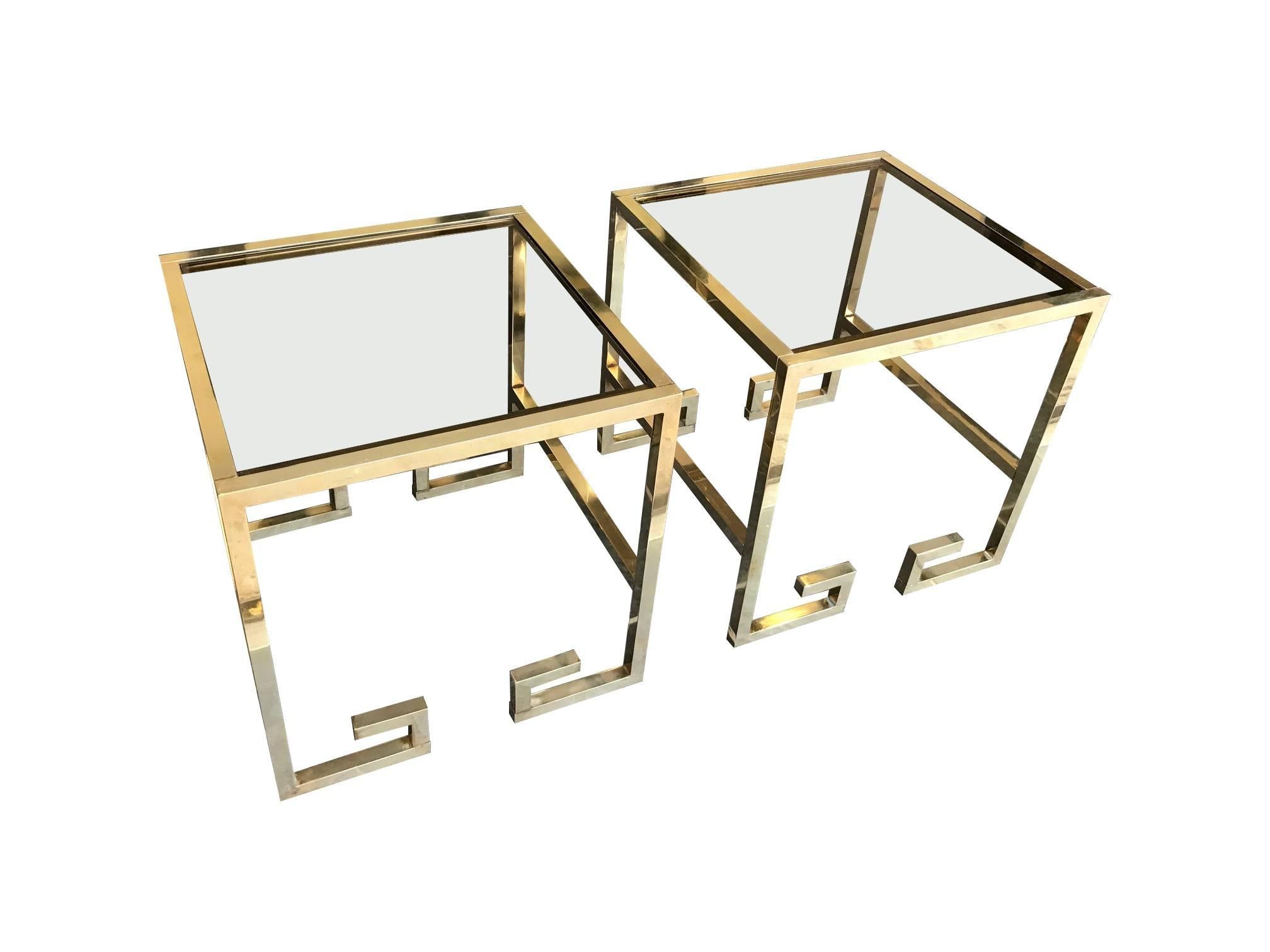 A pair of Italian Greek key design side tables, in brass with smoked glass tops.