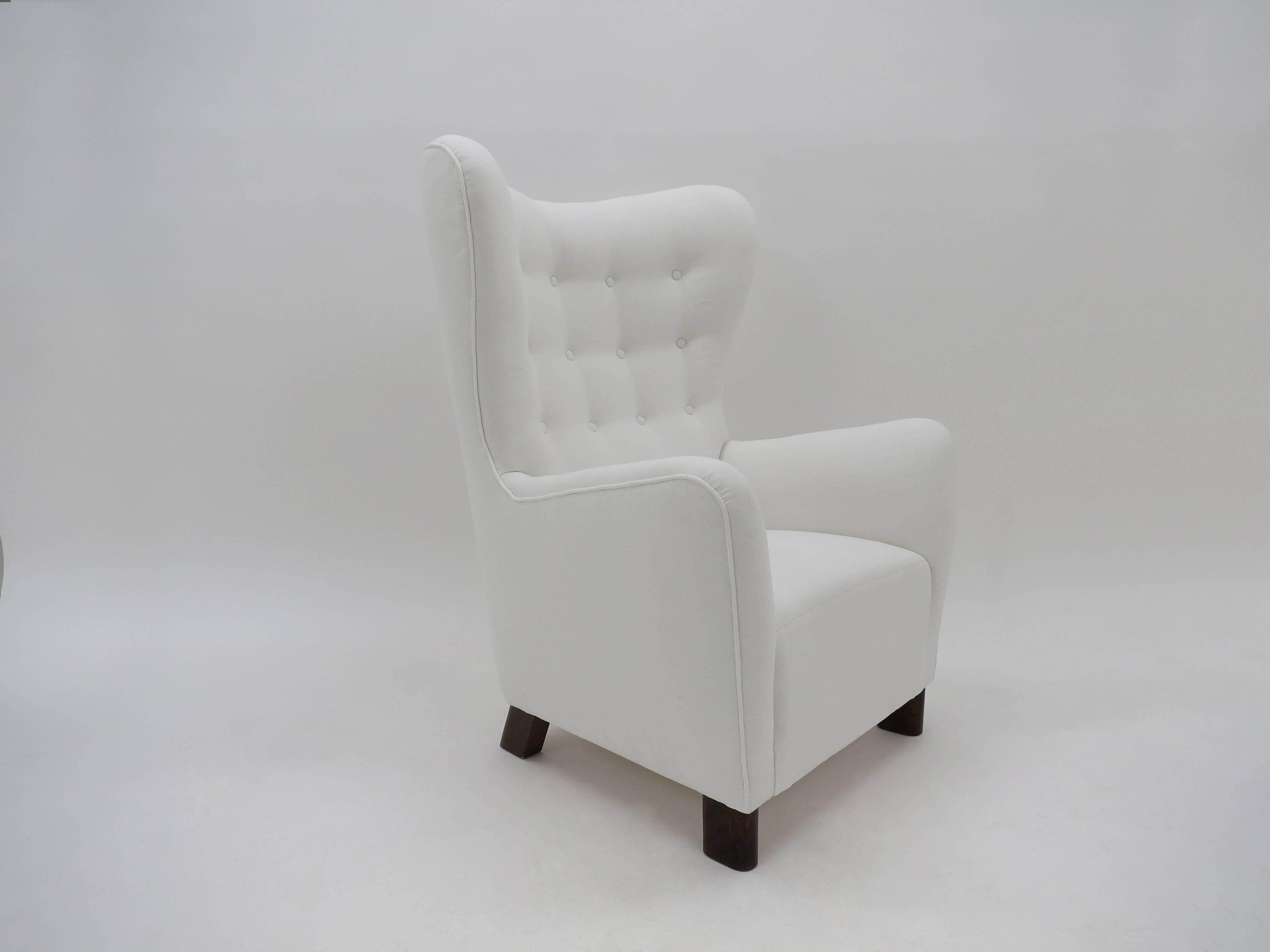 A rare  original Fritz Hansen armchair model number 1669 from the 1940s. This wingback armchair has been reupholstered in linen, resting on lozenge shaped diagonal mahogany legs.

A very beautiful armchair with lovely curves and organic forms that