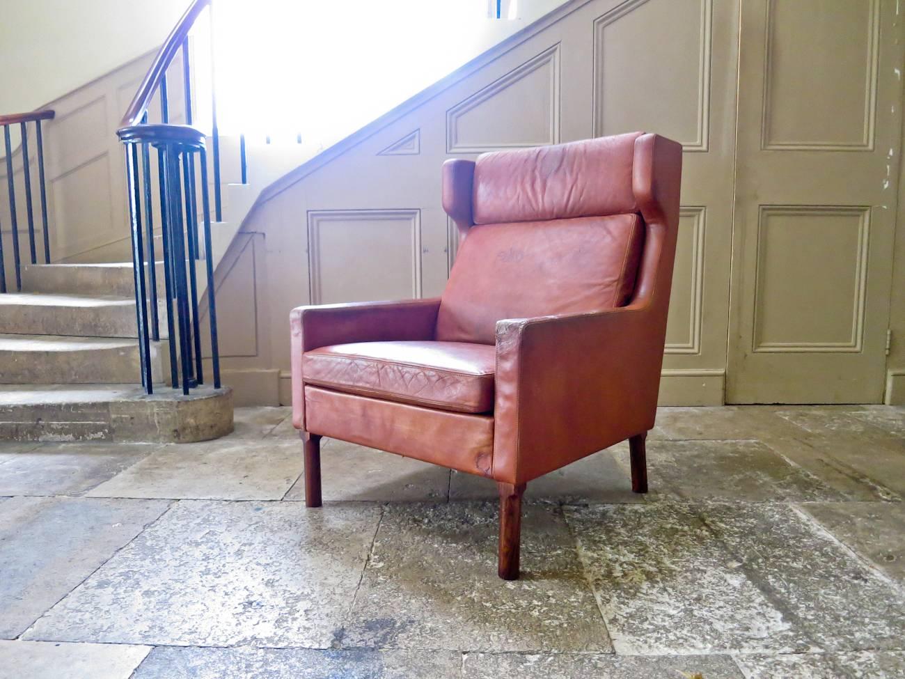 A magnificent leather wingback armchair model 7801 designed by Arne Vodder for Fritz Hansen in the 1960s. Beautiful original patinated cognac leather resting on solid rosewood legs, all in an excellent original condition.

Beautiful rich color and