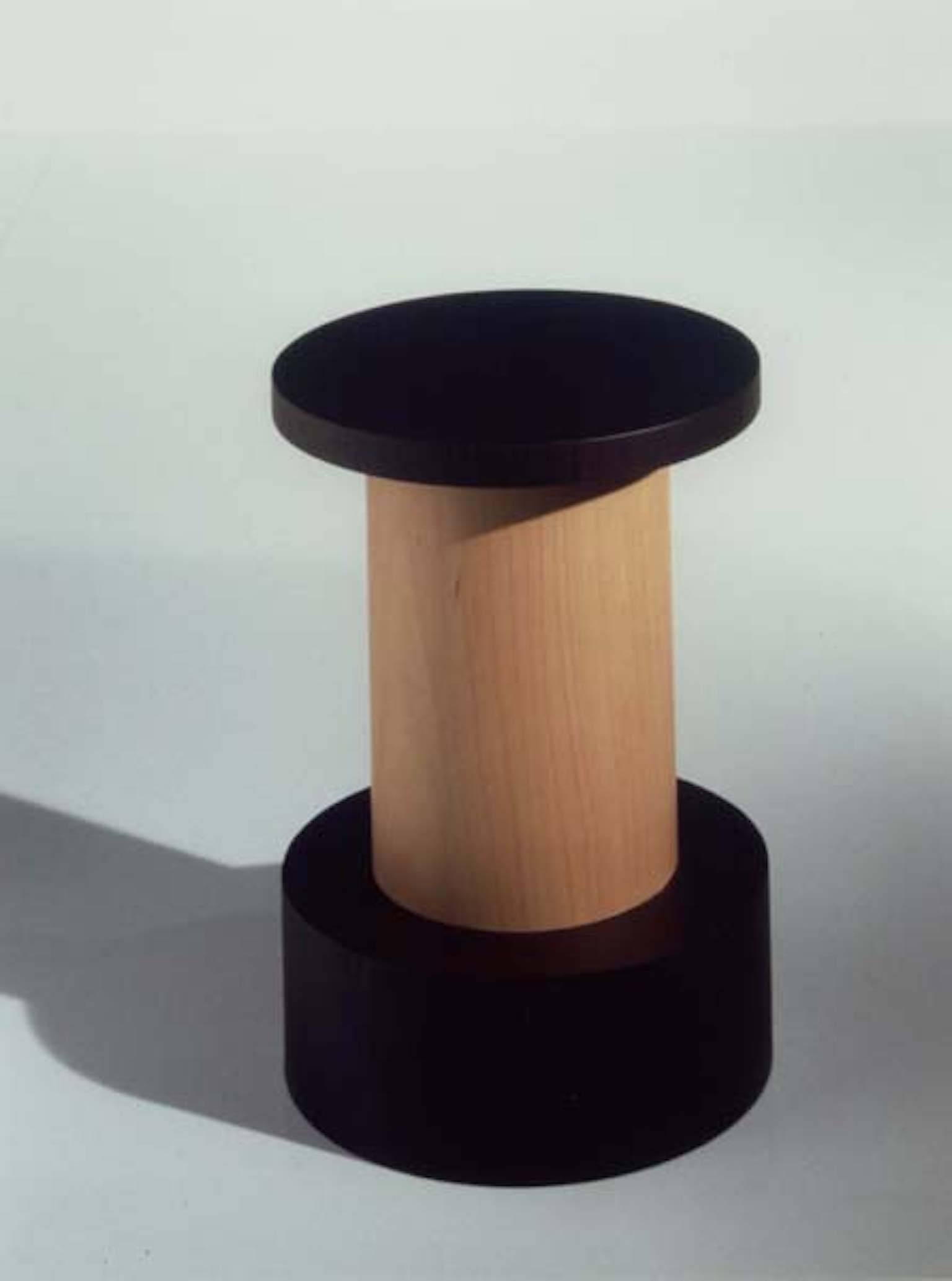A table designed by Ettore Sottsass for Oak Design Edizioni in 2000 for the exhibition Italy, Japan. Exotic wood and stained ash circular pedestal. Producer's metallic plate. Limited edition of 20 copies. Out production.