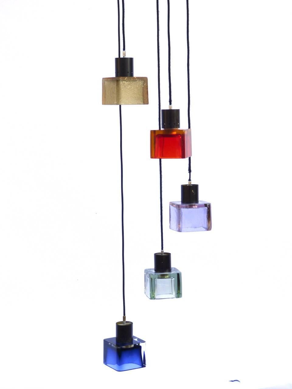 Seguso chandelier designed by Flavio Poli realize in Italy, 1960. Three multicolor blown glass cubes suspended from three adjustable wires, fixed to a brass canopy. 
The dimensions of each single glass cube are: D 13 cm x W 13 cm x H 10 cm.