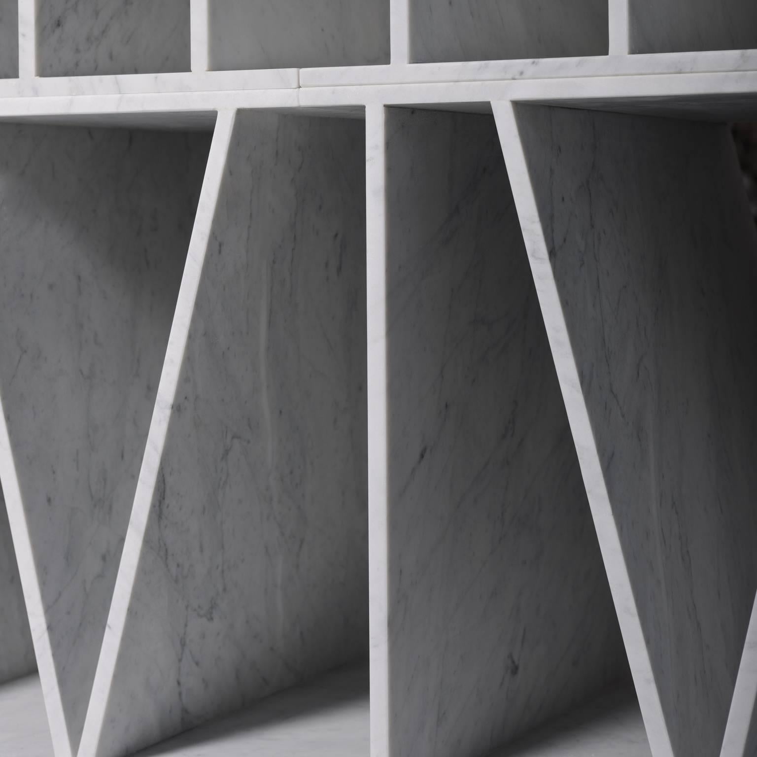Modular bookcase made of white Carrara marble, in the shape of the Roman numerals from I-IV. The overlapping and juxtaposition of these modules simultaneously creates the structure and symbolic form of each bookcase. Designed by Paolo Ullian and