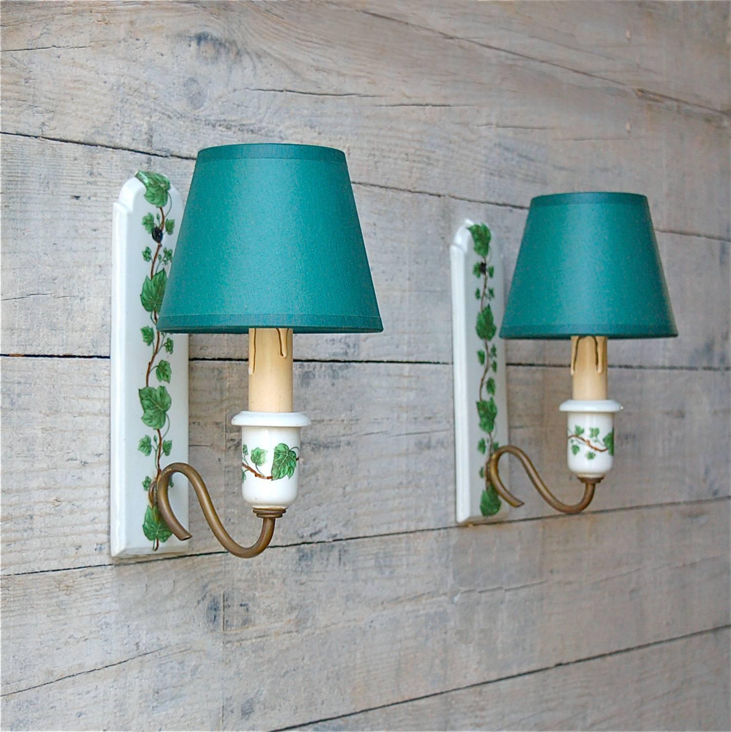 A decorative pair of porcelain candle wall lights with transfer printed decoration of ivy leaves. The green and white wall lights were made in the France in the middle of the 20th century or possibly earlier. The manufacturer also used the motif in
