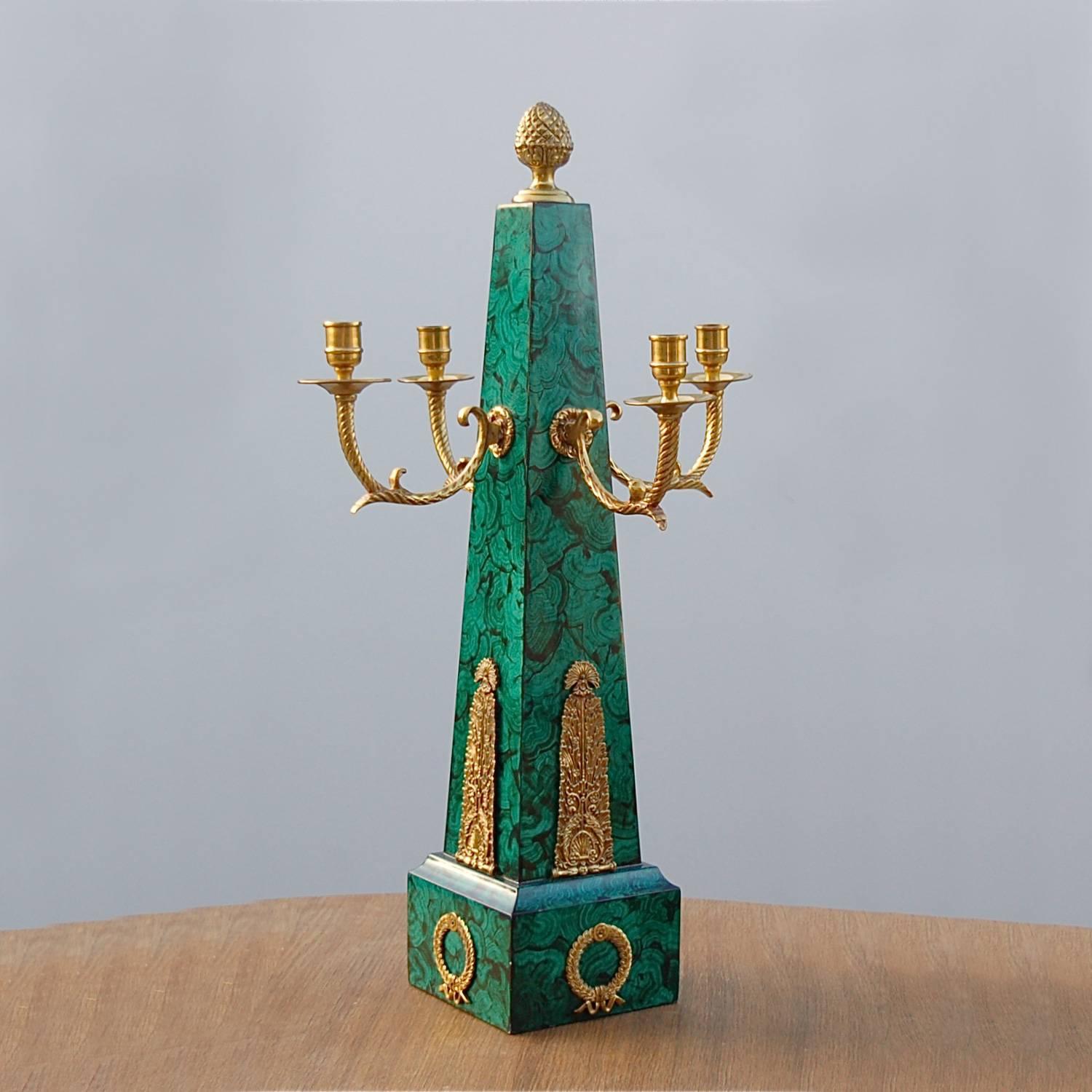 Maitland-Smith are designers and makers of luxury home furniture and decorative objects for the home. This is an example of their work: a large, neoclassical, obelisk-shaped candelabra with a faux malachite finish and four brass candleholders. All