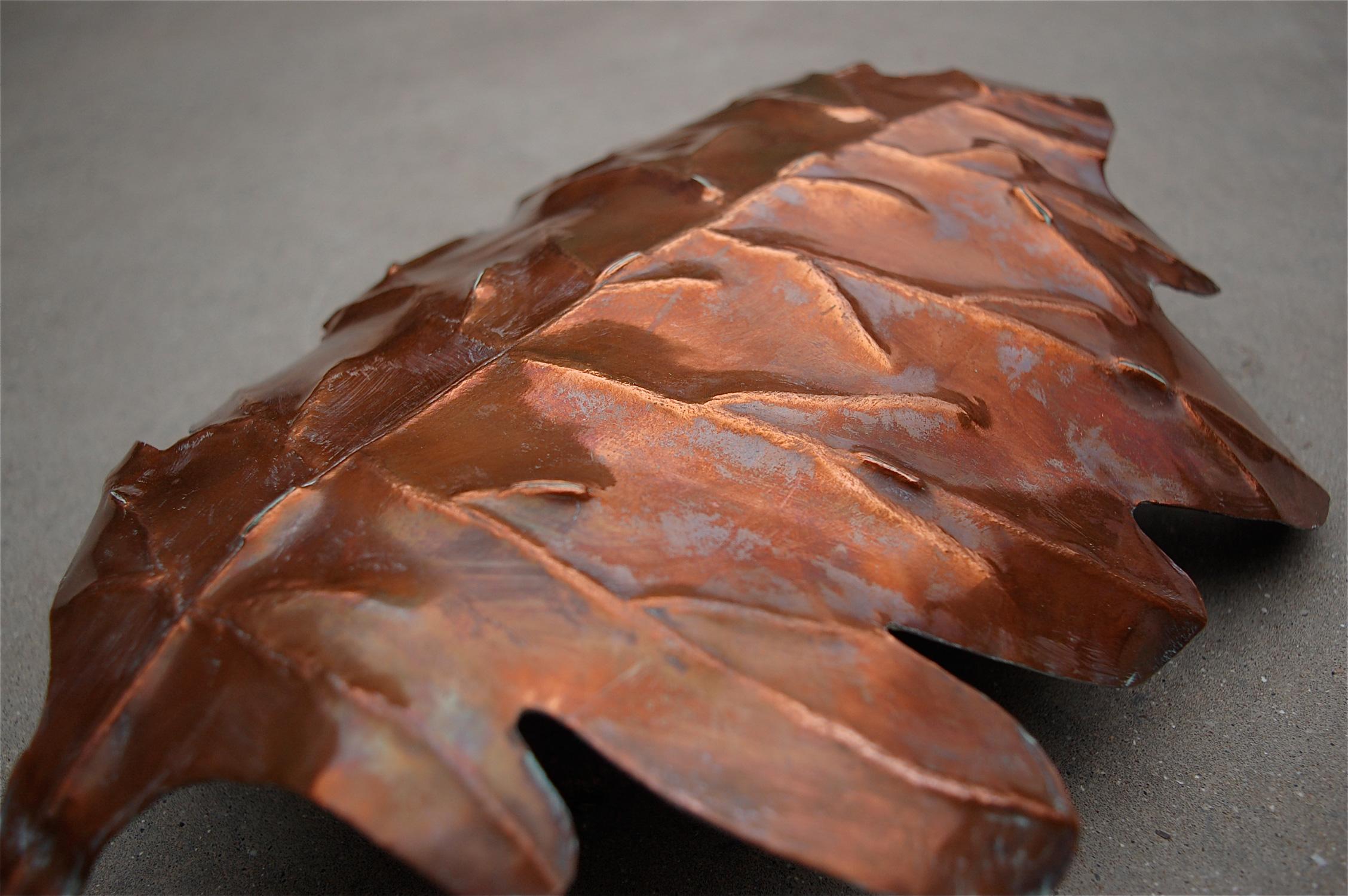 Artisan lighting, one-off piece. This handcrafted crafted wall lamp in the shape of an oak leaf is made of solid copper that has been hand-beaten and moulded into shape. The reflection of the light on the copper creates a cosy atmosphere and warm