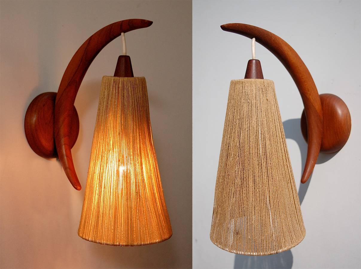 A pair of original teak wall sconces with sisal covered lamp shades from Fog and Mørup of Denmark, designed by Ib Fabiansen in the early 1960s. There is a single socket inside each lamp. The fixtures have a flat brace on the back for mounting and