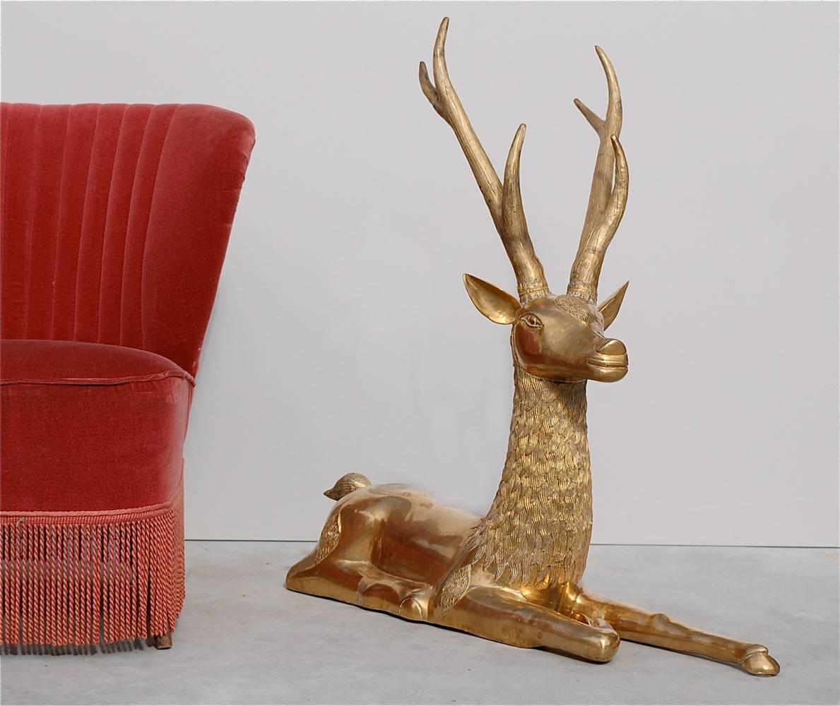 Impressive brass statue with fine detailing of a resting male deer or buck.

We offer a global parcel and door to door freight service as well as 1st dibs white glove delivery service. Any shipping rates featured on a listing act as a reference as