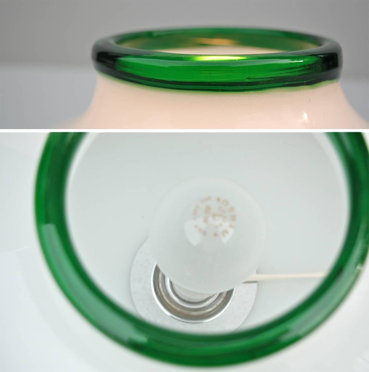 Table or floor lamp from the Morosina series in opaline glass with green edging by eclectic architect and Industrial designer Ettore Sottsass who became one of the most celebrated figures of the late 20th century Italian design scene. 

