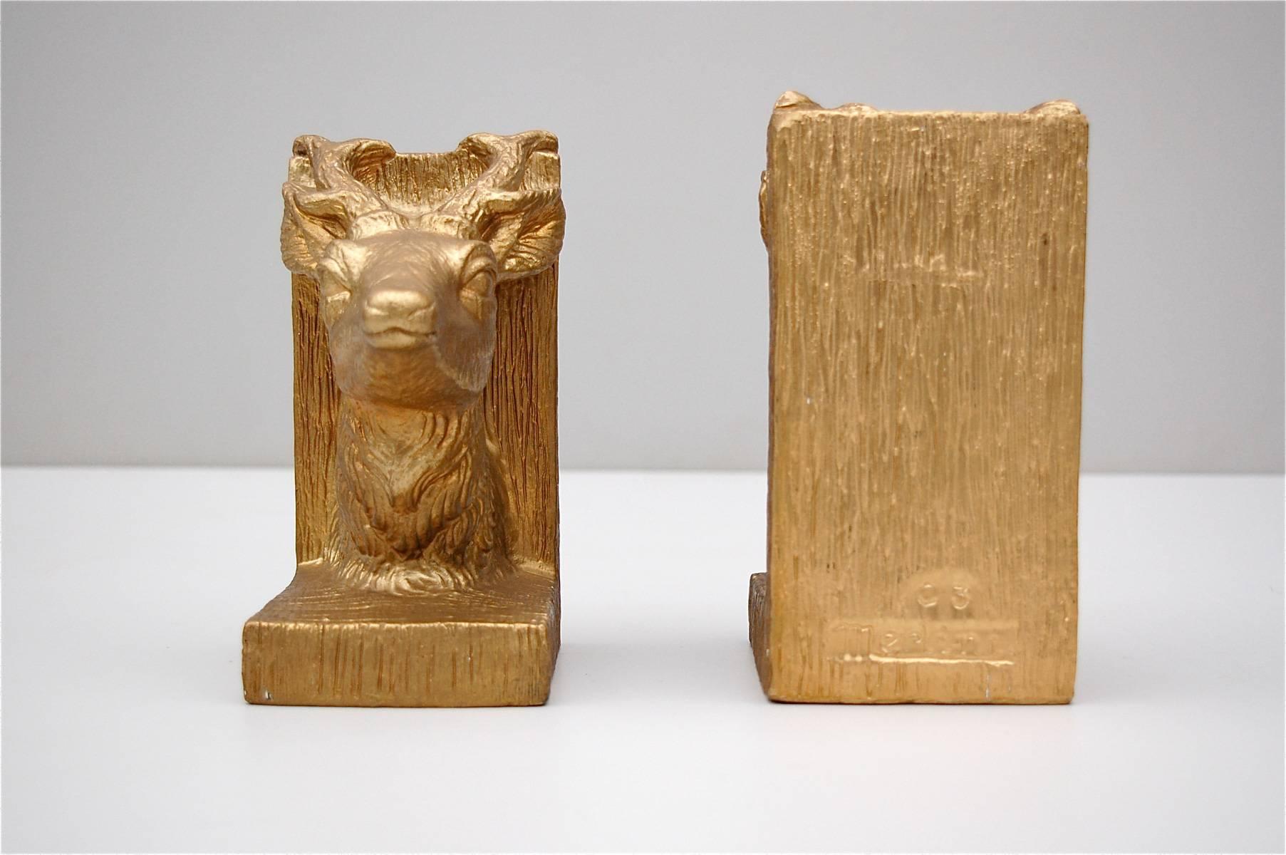 Heavy plaster, gold colored bookends in the shape of a young stag's head, (possibly deer or young buck). Very evocative of that glamorous Hollywood Regency style although these date from slightly later, circa 1950's. The L-shaped supports have a