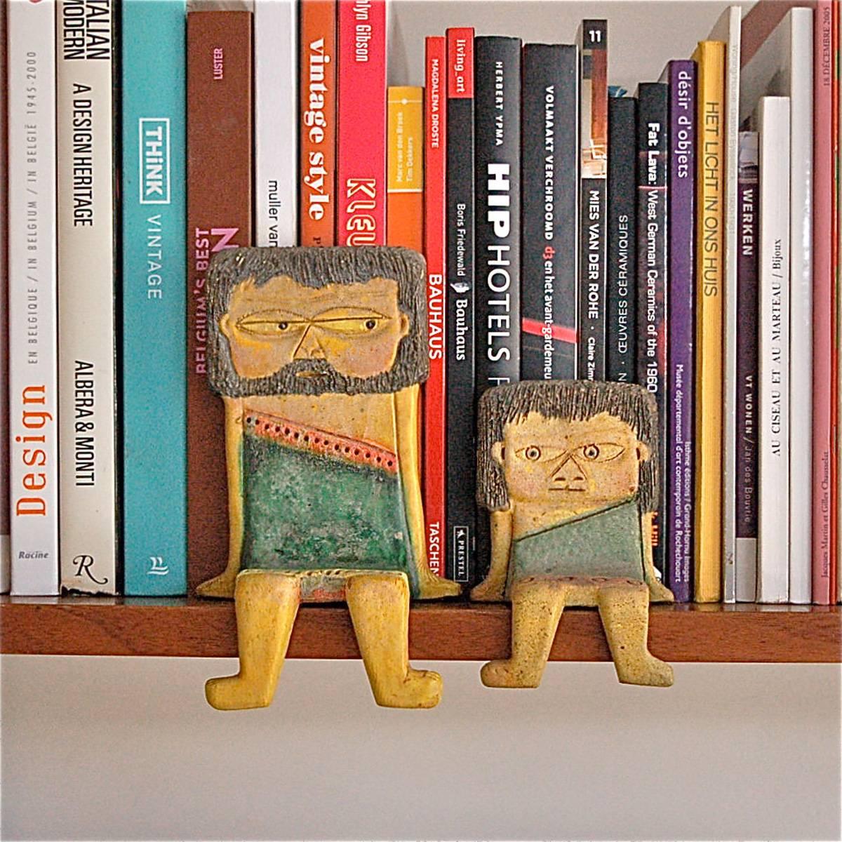 Pair of ceramic figures, depicting a caveman and child, designed to 'sit' on the edge of a shelf. This particular child figurine is very rare. Designed and signed by Italian ceramicist, Marcello Fantoni for Raymor. 

Shipping cost quoted is via