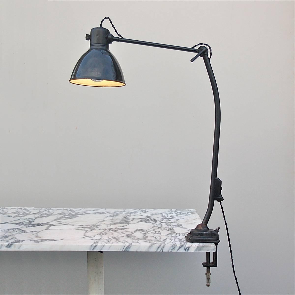 Unique features of this workbench or desk lamp include a solid metal base with rotating ball joint and slightly curved jointed arm which allow the lamp's position to be adjusted. The lamp has been completely rewired by a qualified electrician using