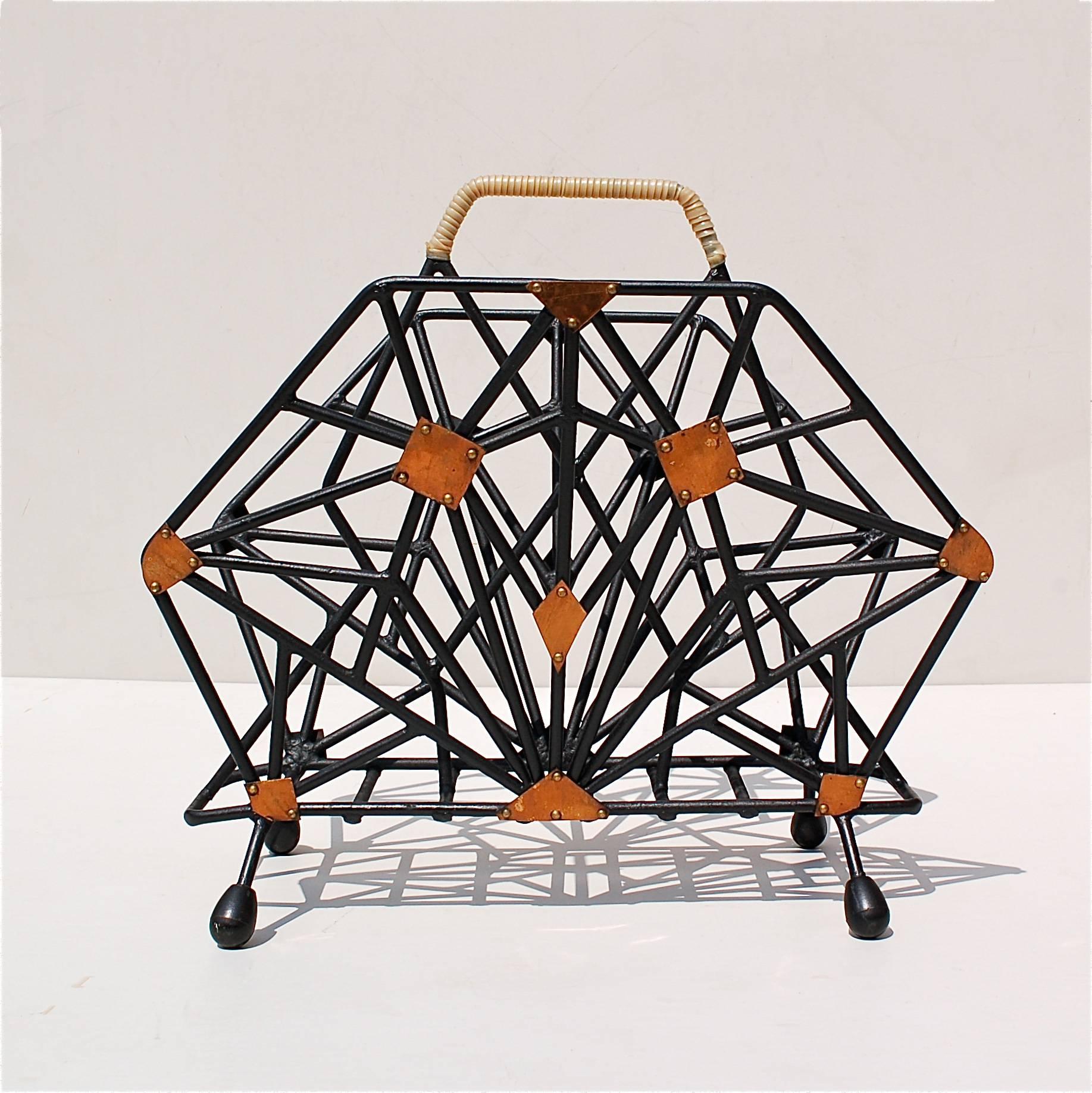 Cubist style magazine rack dating from the 1940s made from thin metal rods welded together to form a complex geometric pattern that is identical on either side. The shape of the side panels is hexagonal, having six straight sides and six angles.