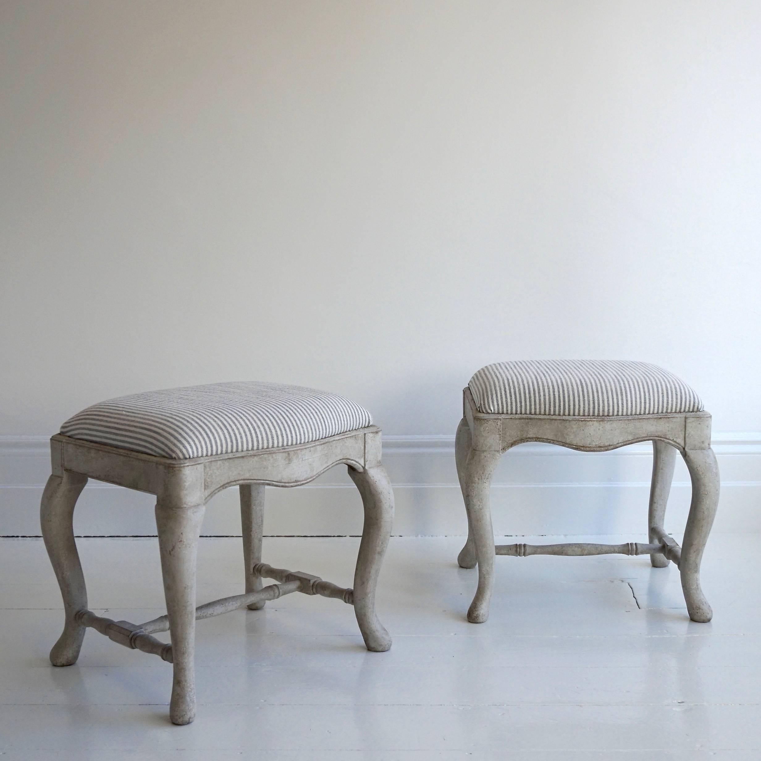 A wonderful pair of bespoke hand-carved Swedish Baroque style tabouret stools upholstered in designers Guild grey ticking.

These beautiful stools are historically accurate, hand-carved renditions of original 1750s Swedish Baroque stools. Our