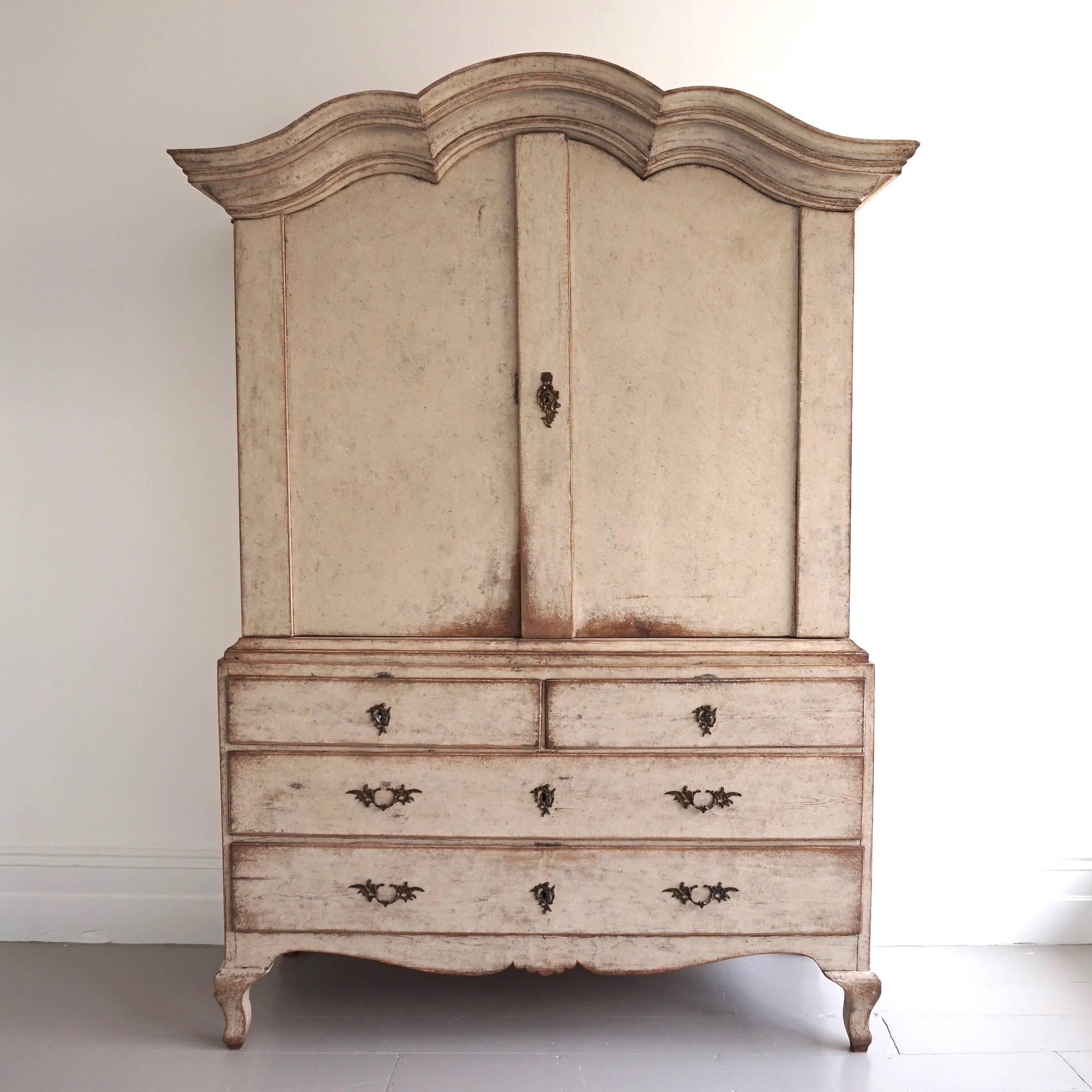 A very rare grand scale 18th century Rococo period cabinet or linen press, with a particularly striking and unusually exaggerated overhanging arched pediment cornice of rare beauty. This cabinet is in excellent condition and has a wonderful antique