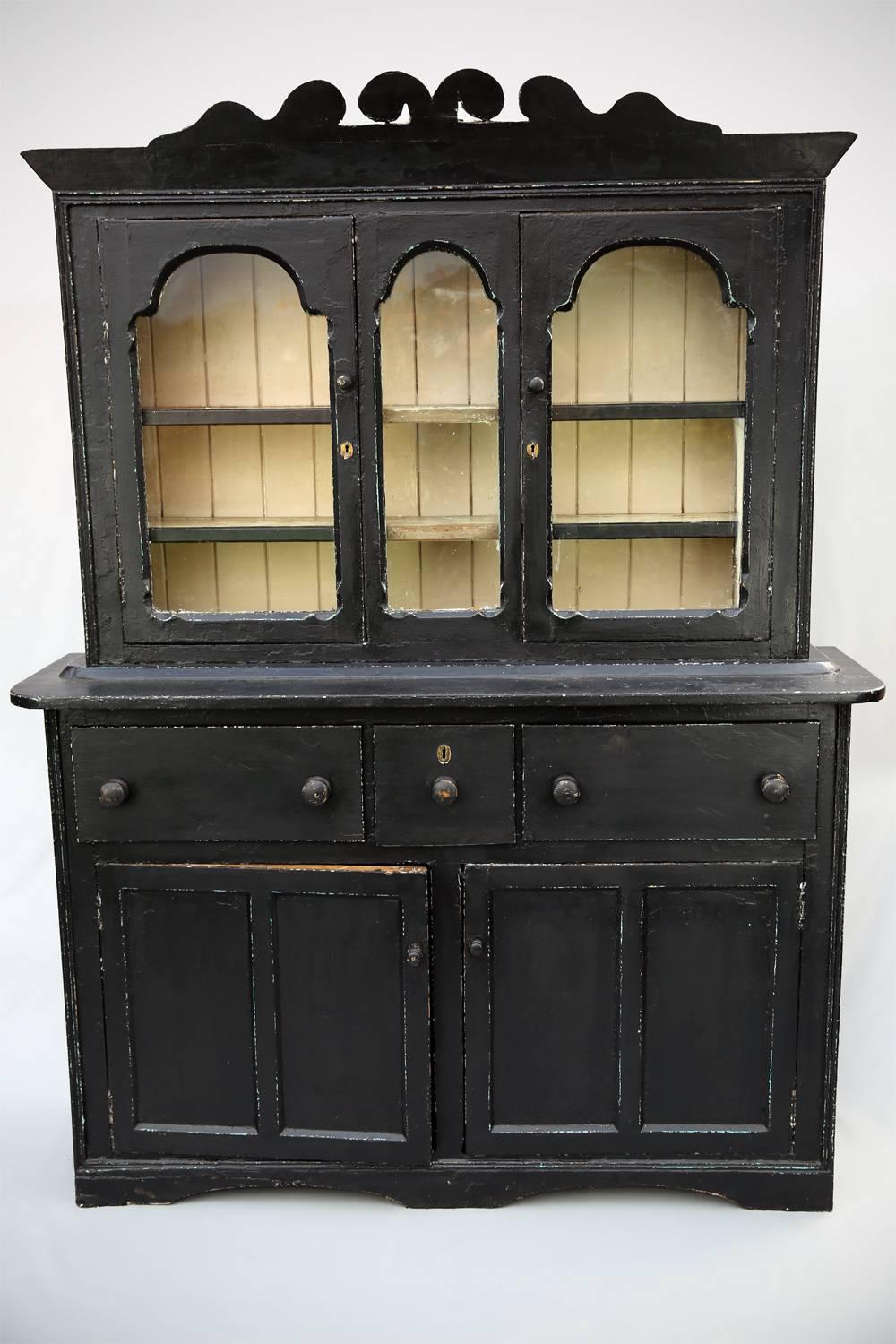 Dress Up: Rather lovely rustic Irish dresser or bookcase dating from the first part of the 19th century. With attractive arched and glazed windows and distinctive carved cornice, this useful piece has three deep, bun-handled drawers over a